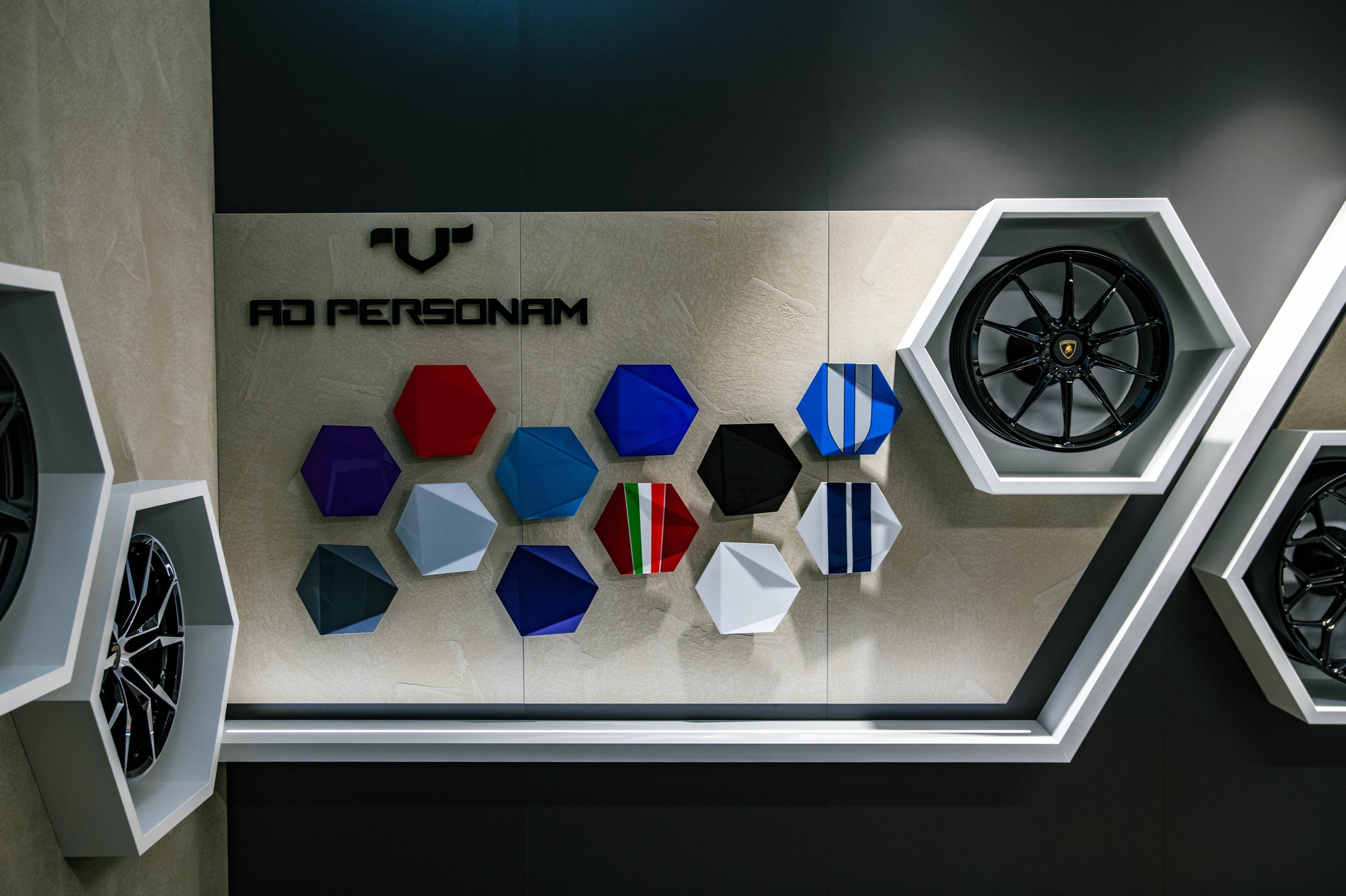 Lamborghini Miami'S Showroom Overhaul Reveals What The Brand'S Retail Future Looks Like 9 Ad personam wall display at lamborghini miami showing hexagonal color samples and black alloy wheels