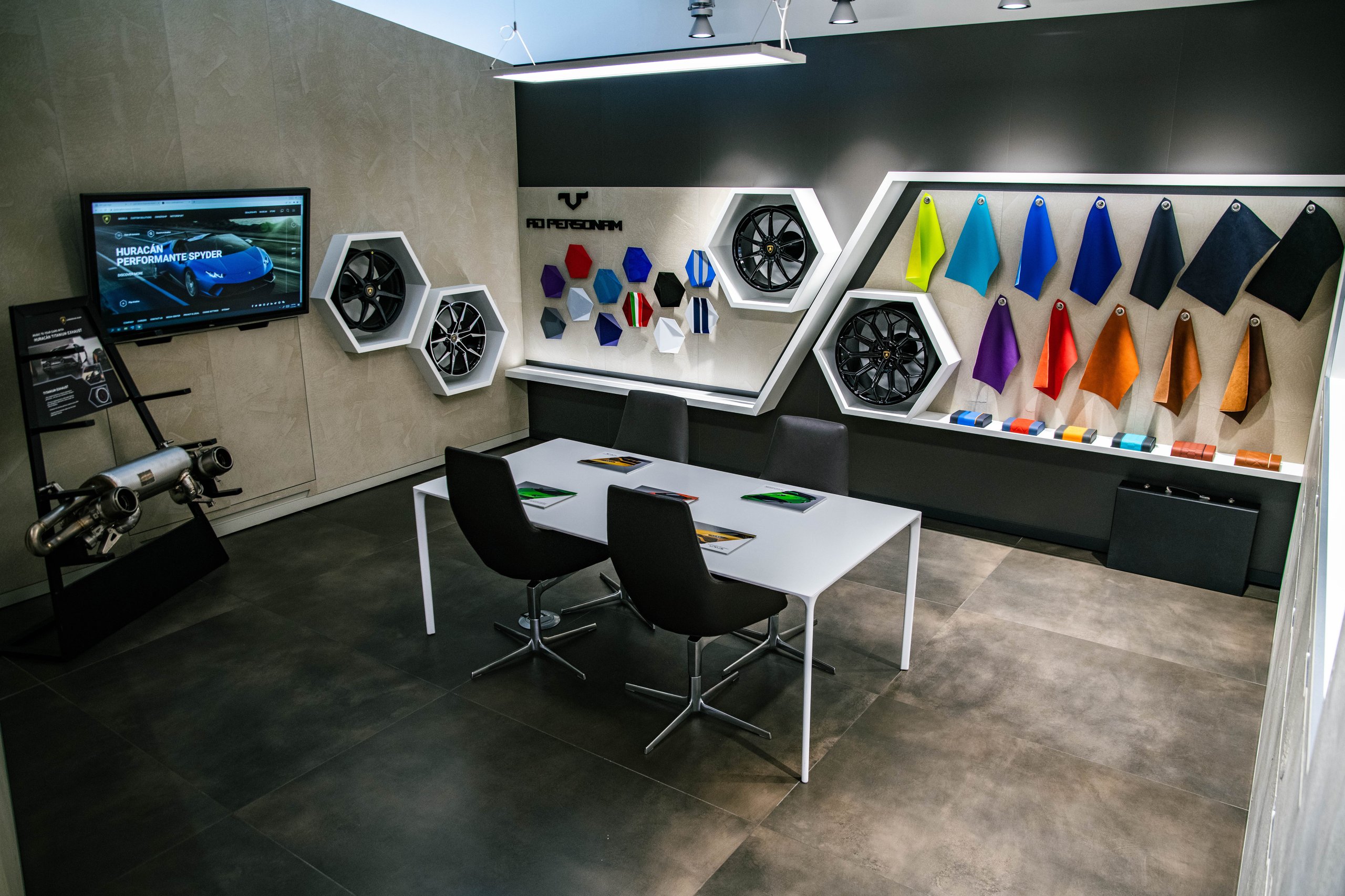 Lamborghini Miami'S Showroom Overhaul Reveals What The Brand'S Retail Future Looks Like 7 Wide view of the ad personam customization studio at lamborghini miami with consultation table, display screens, and material sample walls