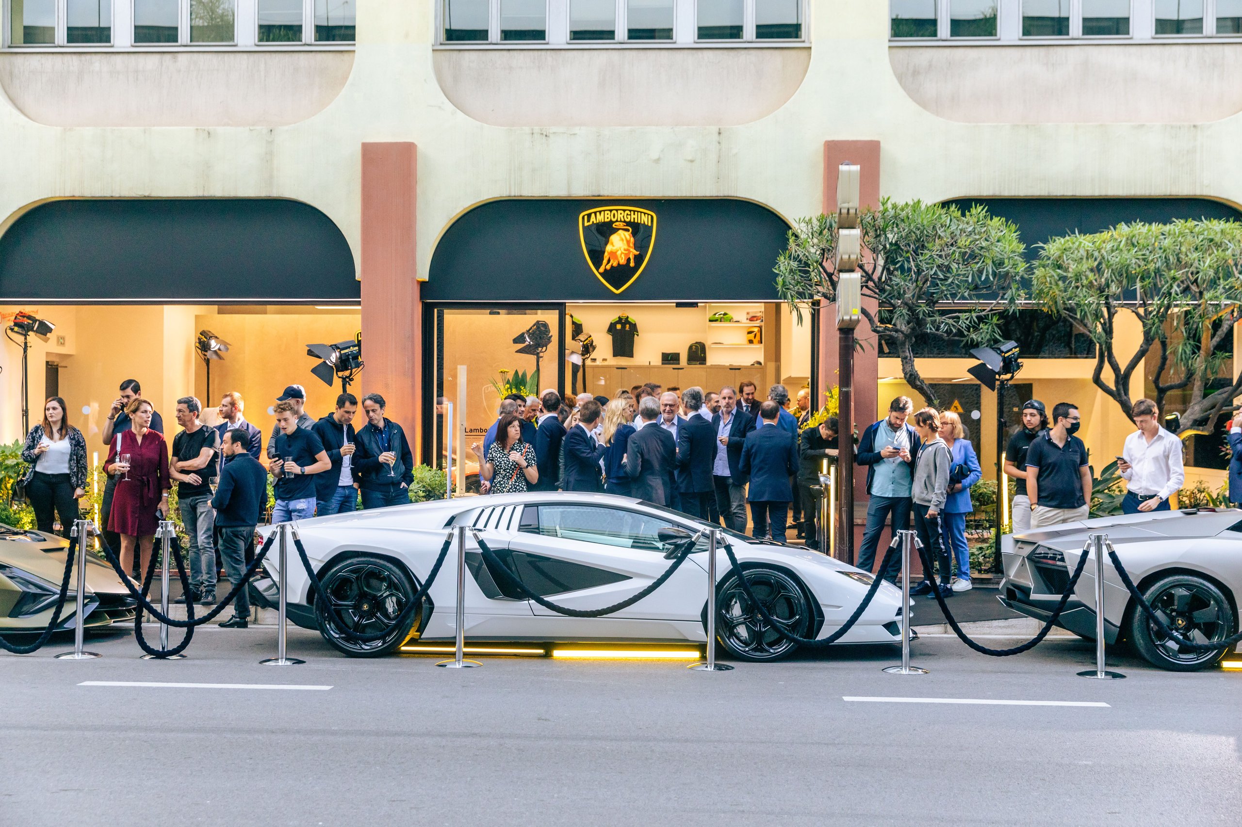 Lamborghini Monaco: How A 218-Square-Meter Showroom Became The Brand'S Riviera Calling Card 3 White lamborghini countach lpi 800-4 roped off on a monaco street with guests gathered near the brightly lit lamborghini showroom entrance