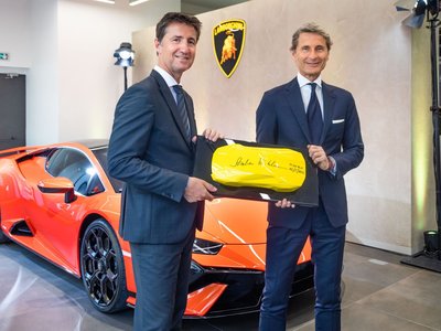 Lamborghini Monaco: How A 218-Square-Meter Showroom Became The Brand'S Riviera Calling Card 2 Two executives hold a commemorative plaque in front of an orange lamborghini huracan tecnica at the new lamborghini monaco dealership opening
