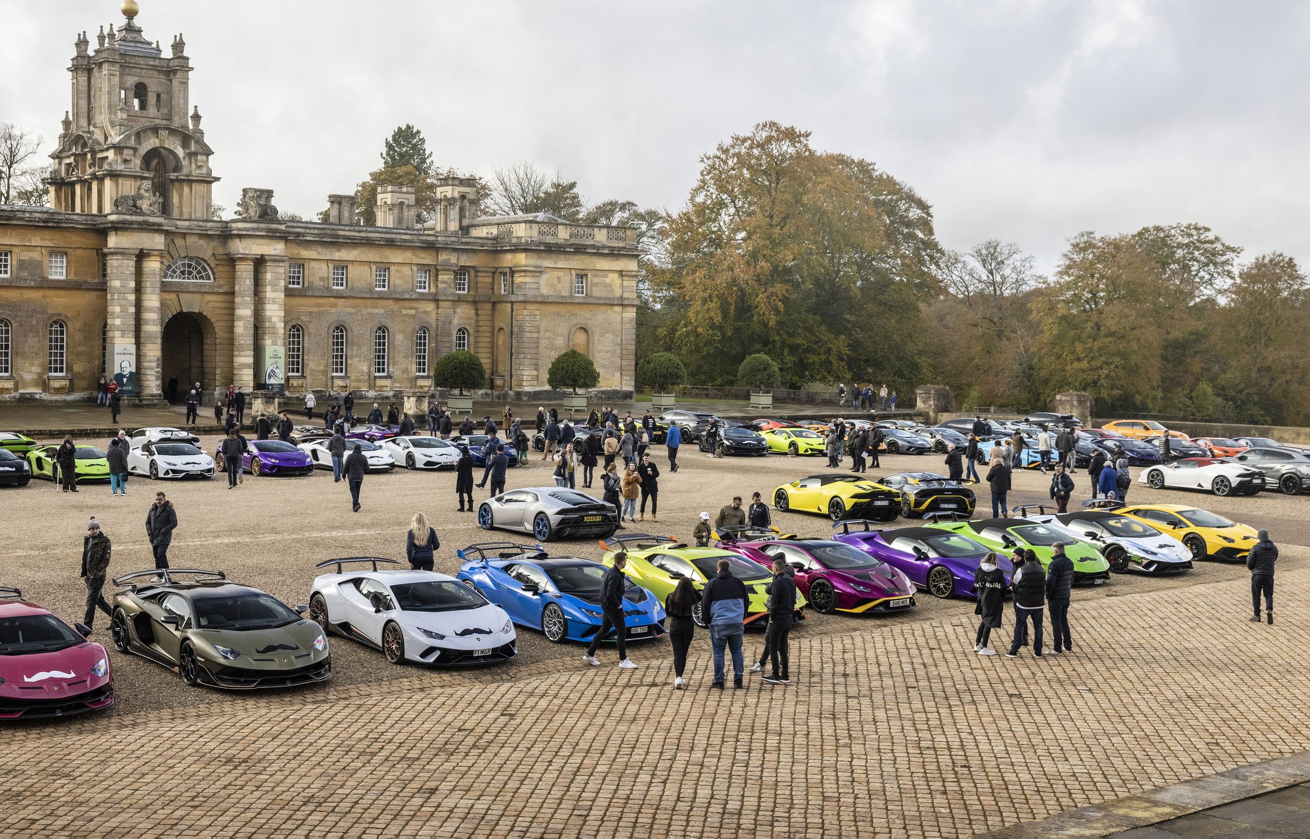 Lamborghini'S Global Movember Bull Run Turned 200 Supercars Into Rolling Billboards For Men'S Health 3 Large gathering of colorful lamborghini models parked on cobblestone plaza in front of a grand historic building during movember event
