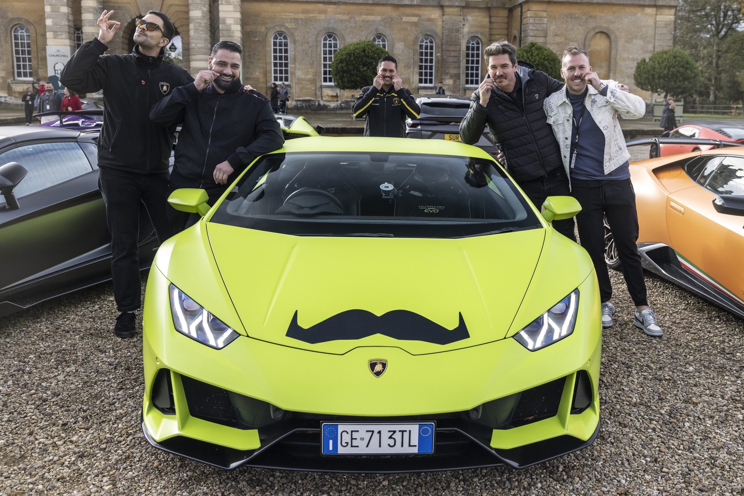 Lamborghini'S Global Movember Bull Run Turned 200 Supercars Into Rolling Billboards For Men'S Health 5 Five men posing playfully around a green lamborghini huracán evo with movember mustache decal at blenheim palace