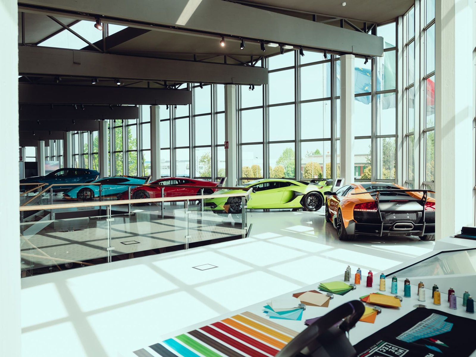 Wide view of the renovated Automobili Lamborghini Museum interior showcasing classic and modern supercars in a bright, open gallery space