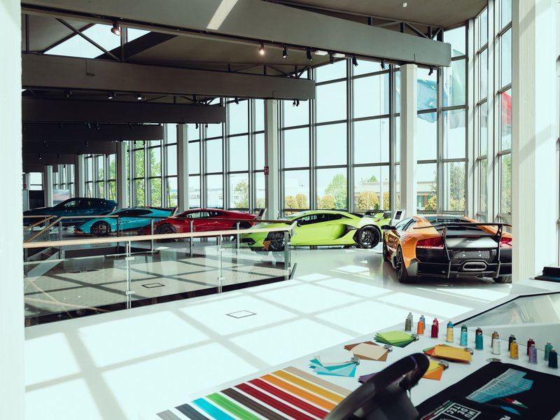Wide view of the renovated Automobili Lamborghini Museum interior showcasing classic and modern supercars in a bright, open gallery space