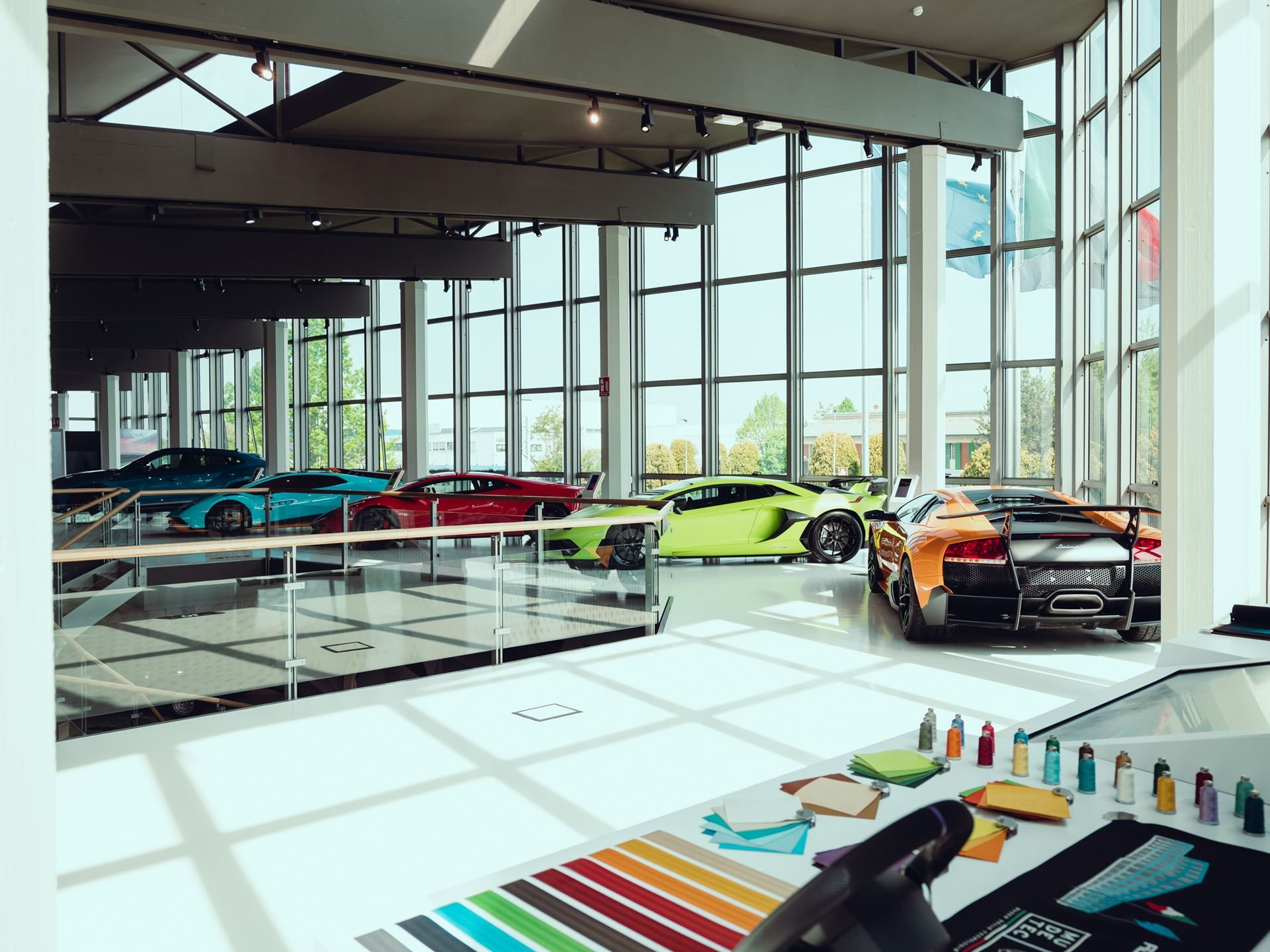 Wide view of the renovated automobili lamborghini museum interior showcasing classic and modern supercars in a bright, open gallery space