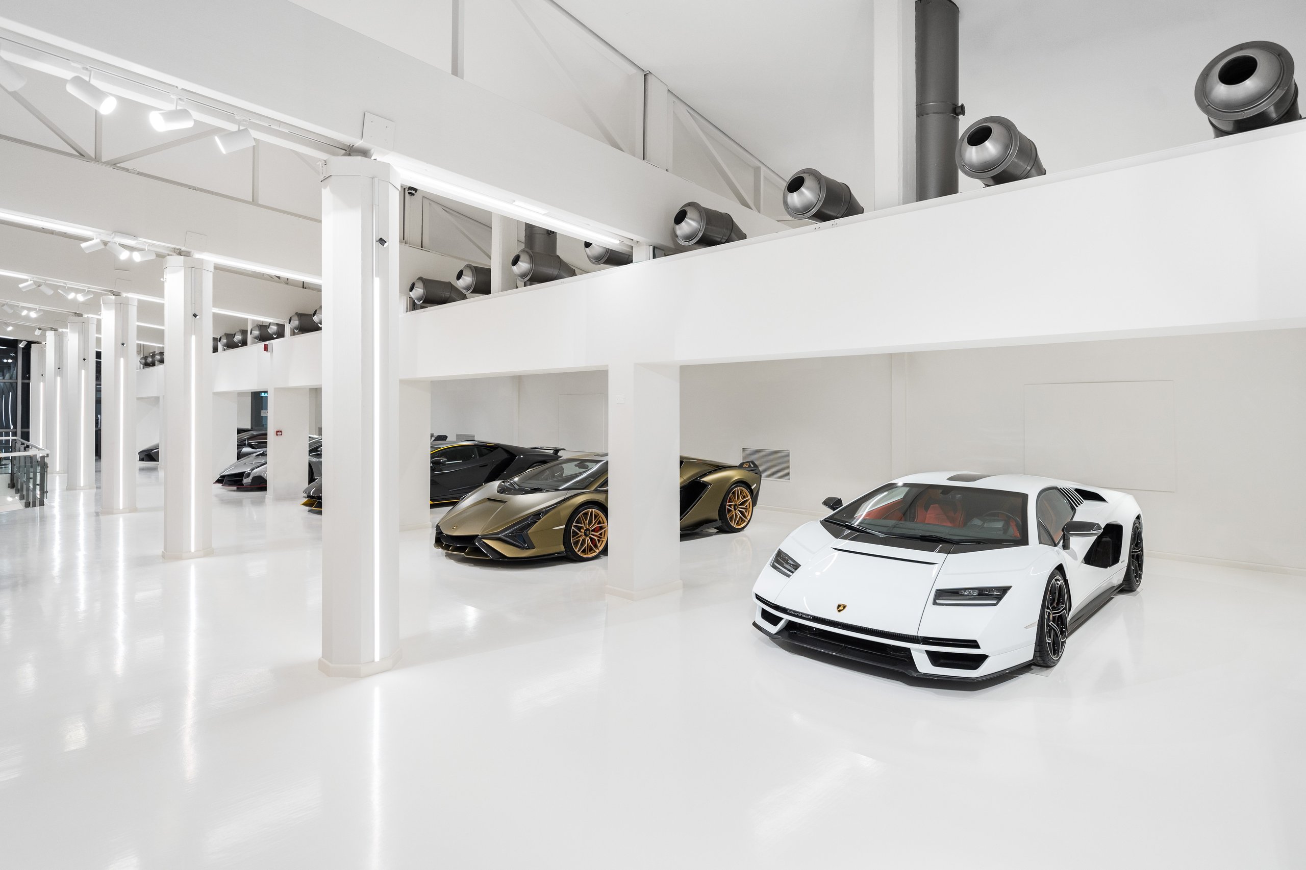 White countach lpi 800-4 and gold sián fkp 37 displayed on a pristine white floor in the few-off section of the museum
