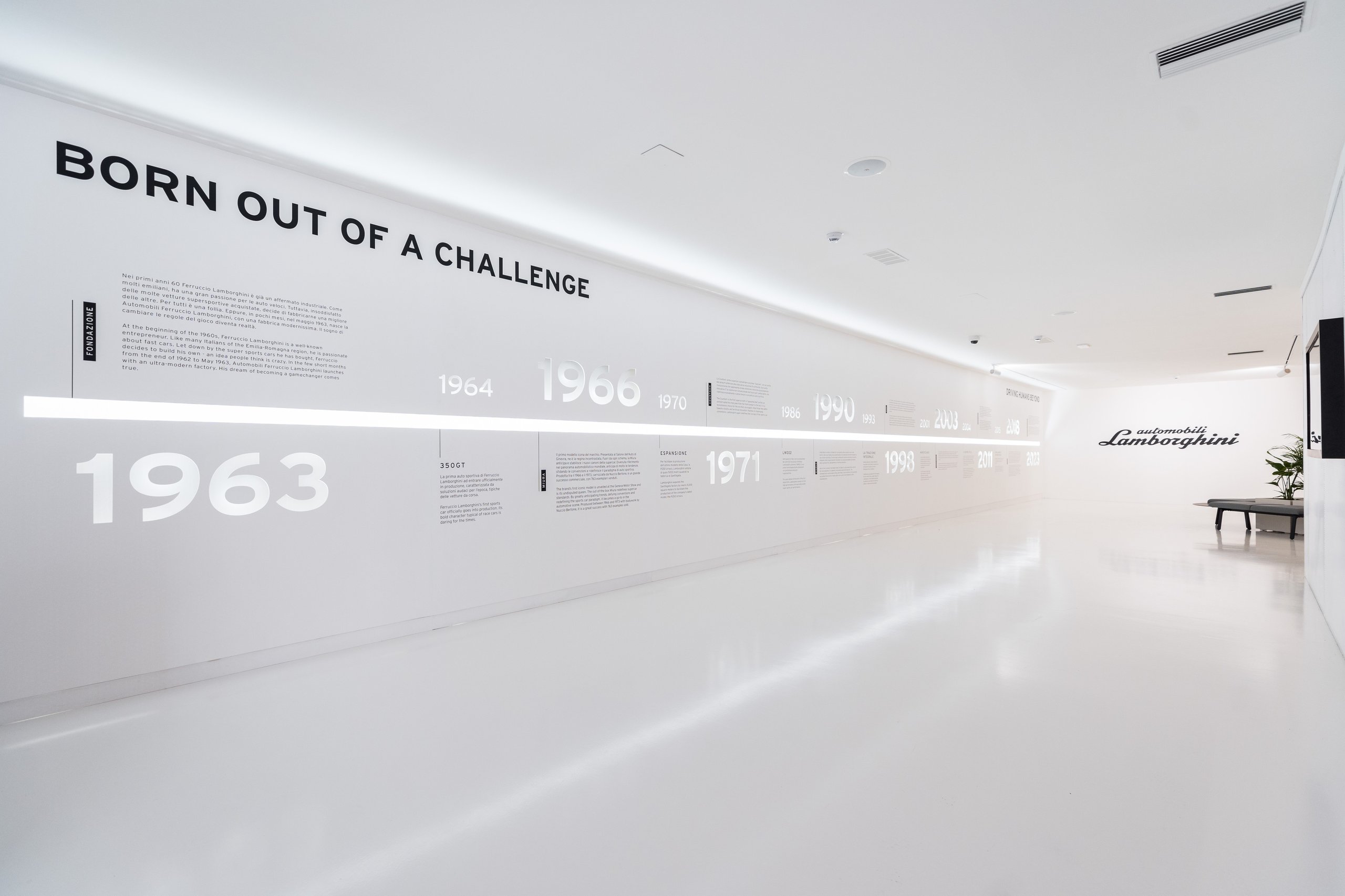 Minimalist museum wall display with timeline of key dates and 'born out of a challenge' text