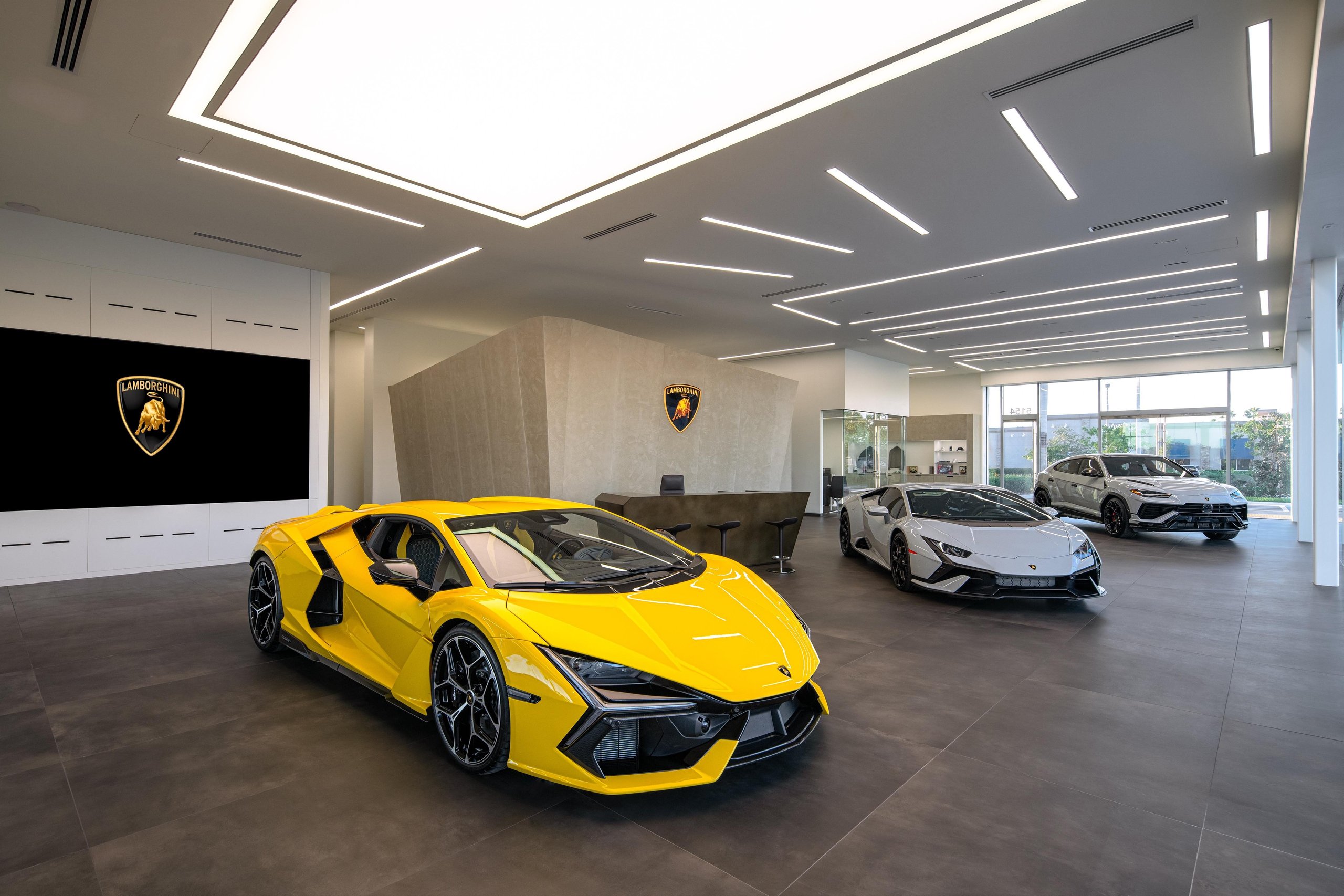 Lamborghini Naples: Why Florida'S Sixth Showroom Tells A Bigger Story About The Brand'S Us Ambitions 9 Interior view of the lamborghini naples showroom with a yellow revuelto in the foreground and huracan and urus behind it