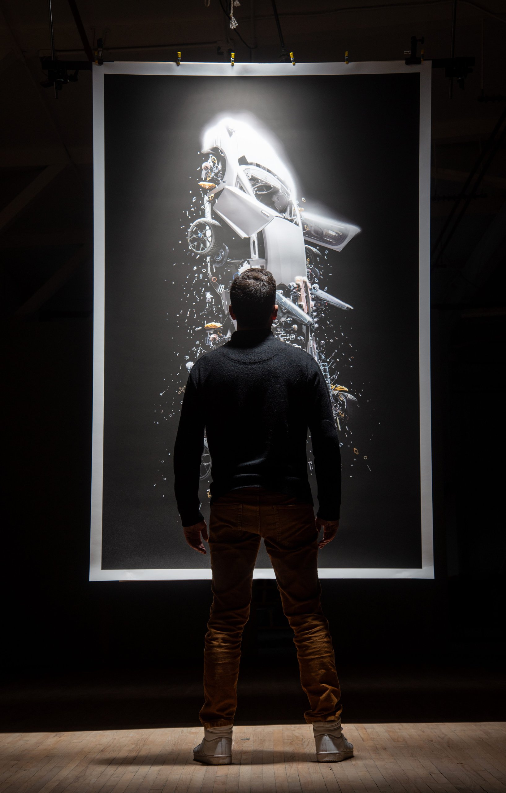 Lamborghini'S 'Space Time Memory' Nft Pairs Iss Carbon Fiber With 600-Million-Pixel Art Of An Exploding Ultimae 9 A viewer contemplates a large illuminated print of fabian oefner's deconstructed lamborghini artwork in a dark gallery setting