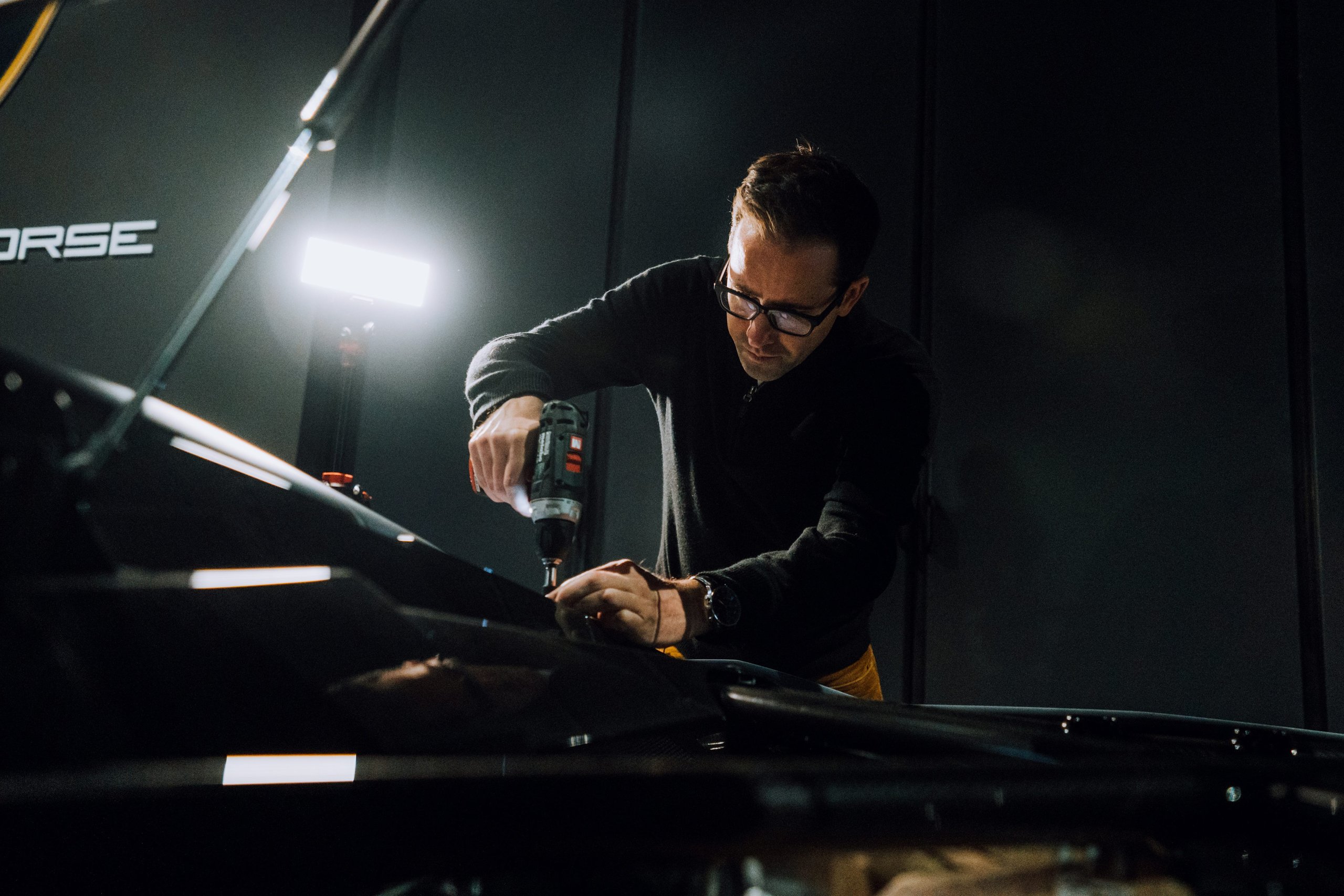 Lamborghini'S First Nft Sends Carbon Fiber To Space, Then Pairs It With Digital Art 3 Fabian oefner uses a power drill on a dark vehicle component in a dimly lit workshop during the space time memory project
