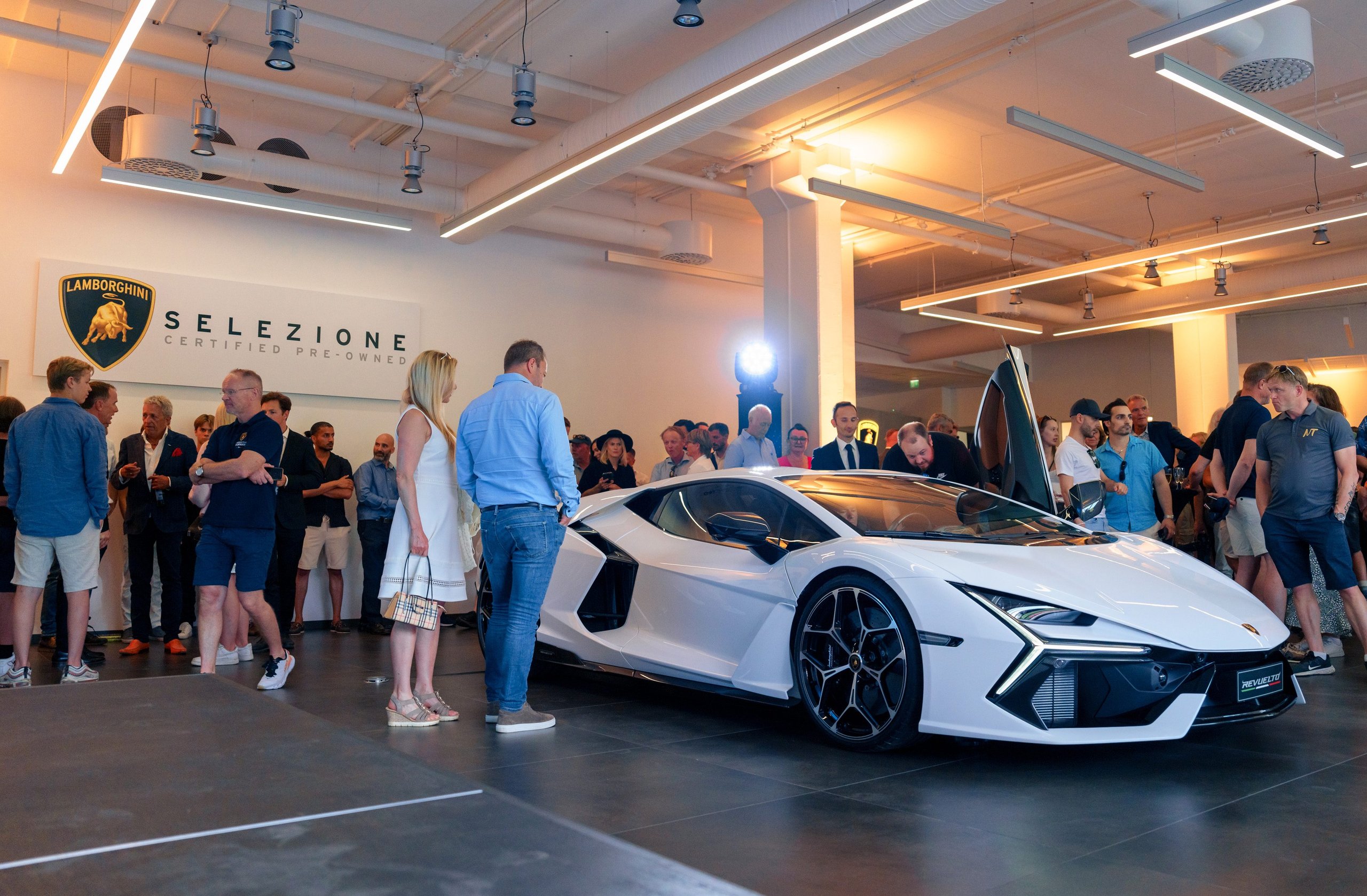 White lamborghini sián fkp 37 displayed at the lamborghini oslo grand opening event with guests admiring the hypercar