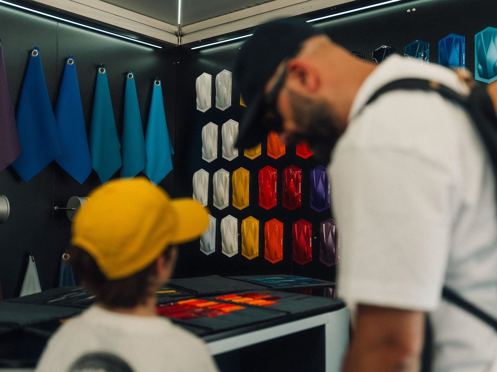 A father and child examining Lamborghini paint samples and material swatches at a brand event