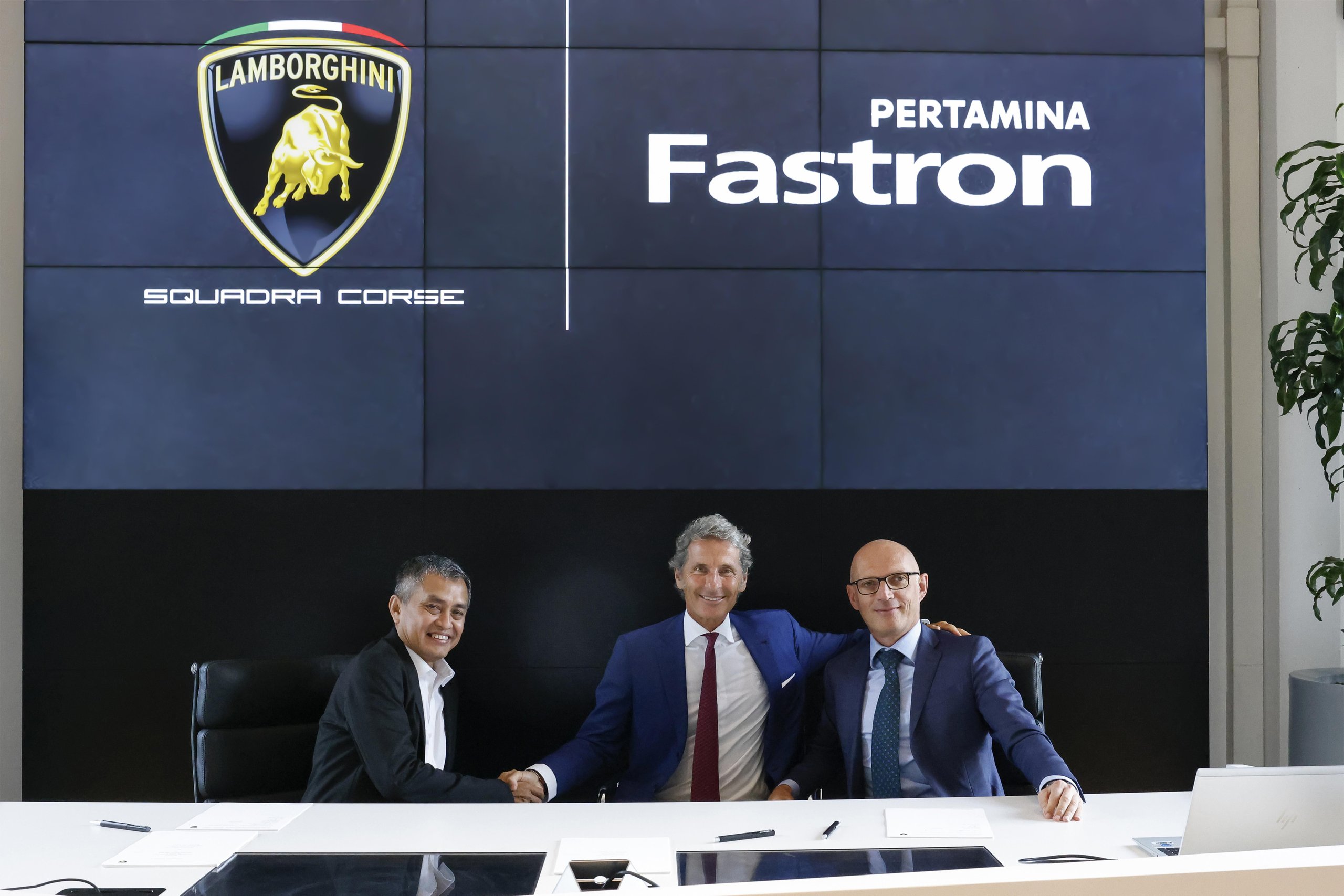 Lamborghini Renews Pertamina Lubricant Partnership Through 2025, Covering Super Trofeo, Gt3, And Sc63 Lmdh 3 Three men in business attire shaking hands at conference table with lamborghini and pertamina fastron logos on screen behind them