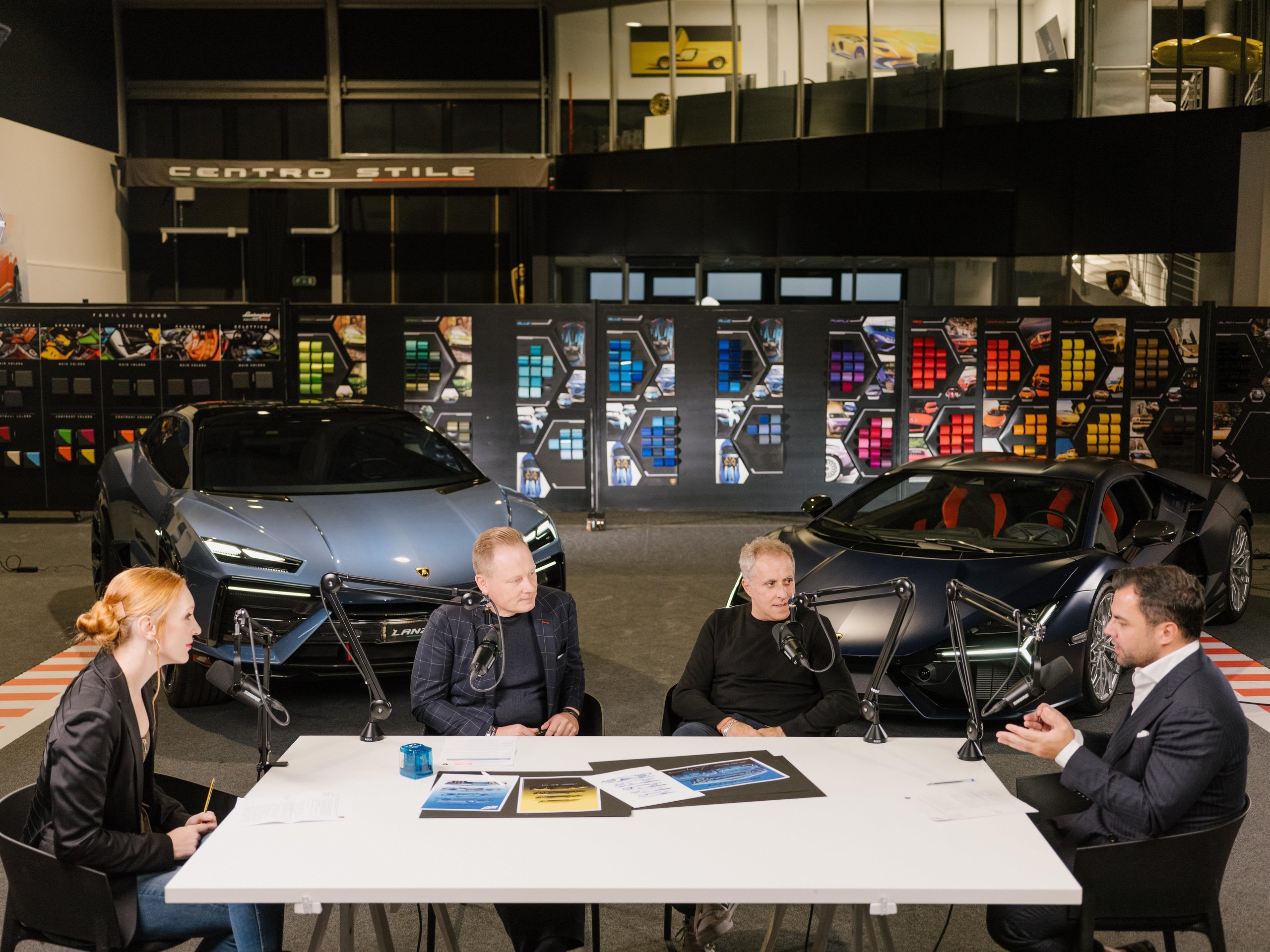 Lamborghini'S Design Chief Reveals How Depeche Mode And Vinyl Sleeves Shaped The Cars You Want To Buy 3 Four individuals including mitja borkert seated around a table with microphones, lamborghini lanzador and revuelto visible in the background