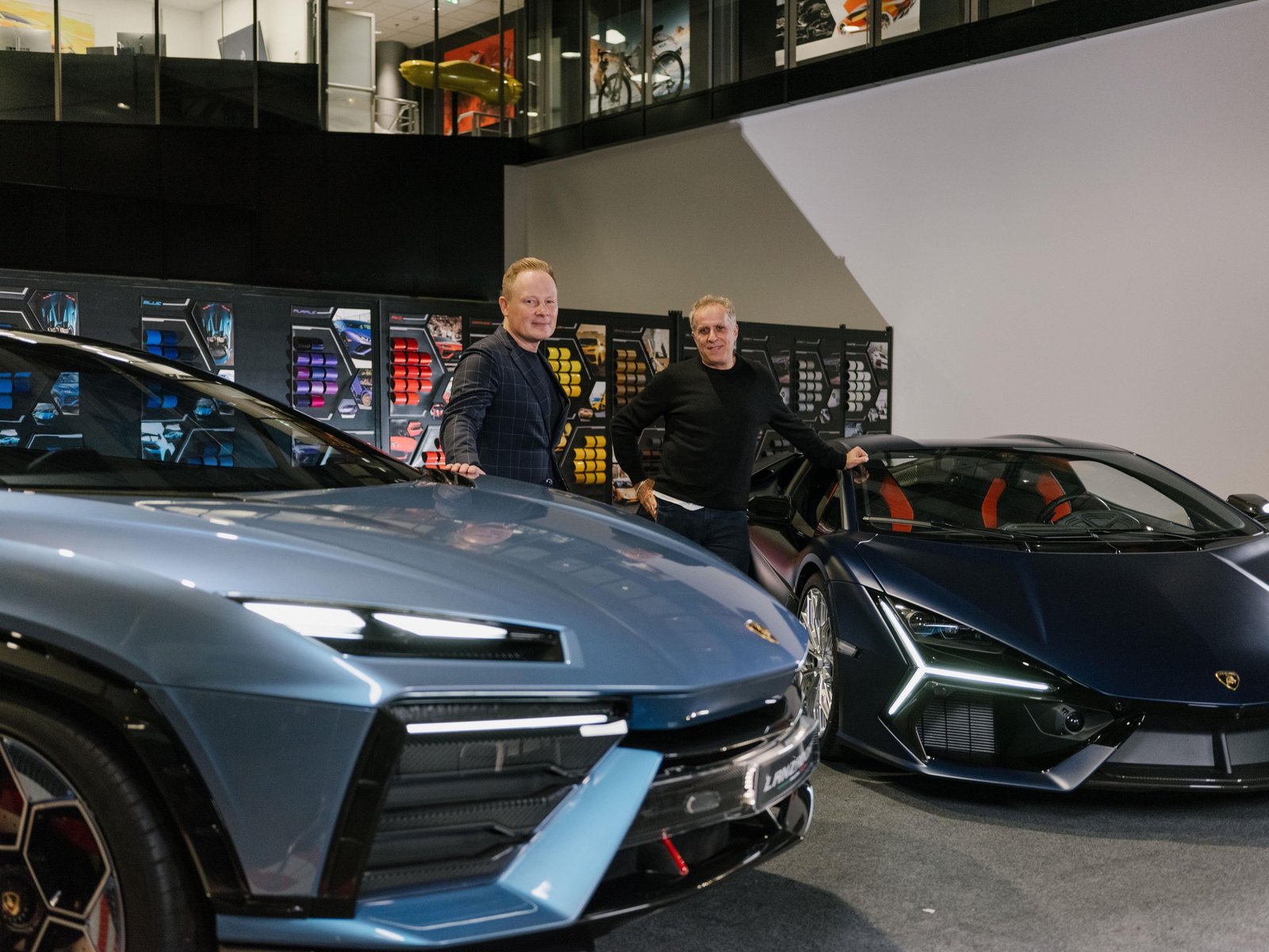 Lamborghini Head of Design Mitja Borkert and Simon Halfon standing between the Lamborghini Lanzador concept and Revuelto in a showroom