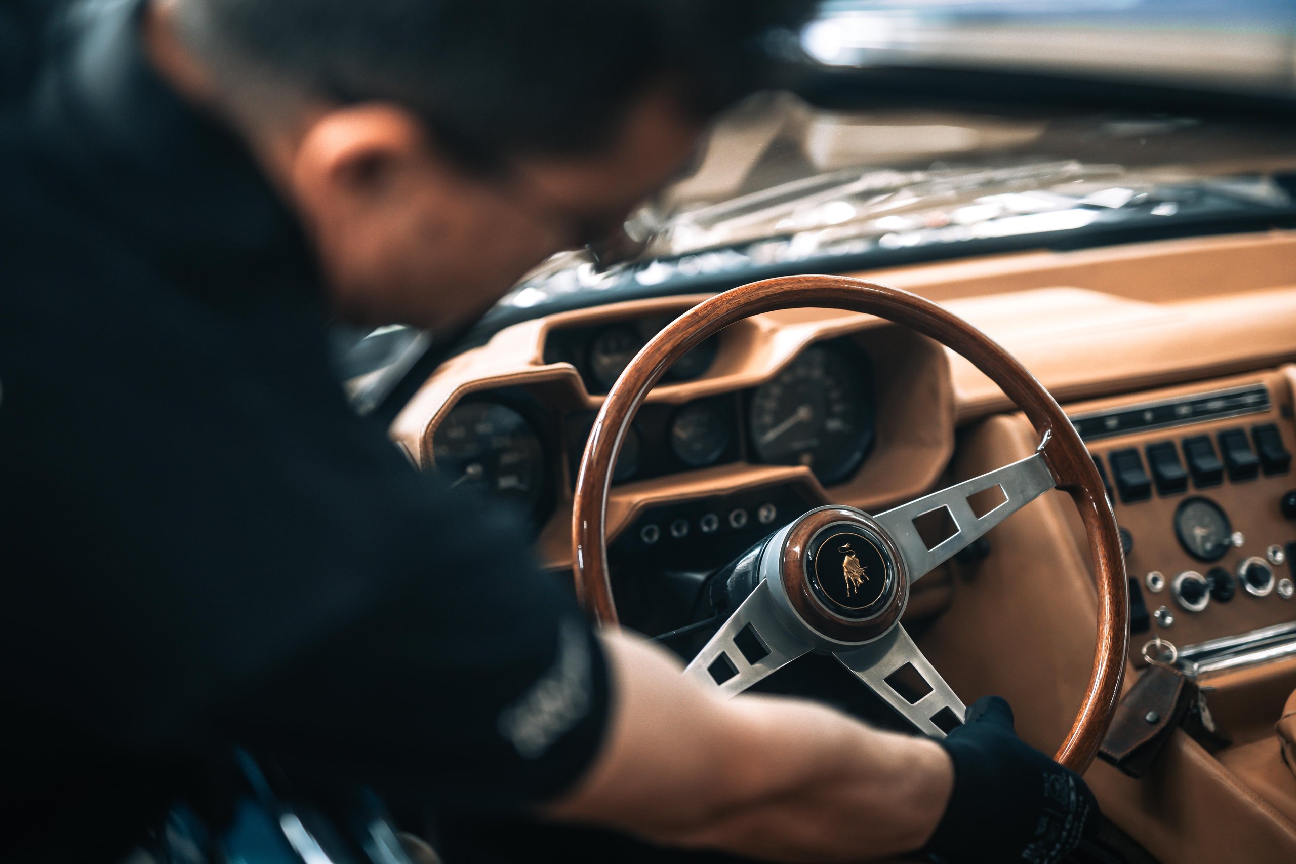 Polo Storico At Ten: Why Lamborghini Let Collectors Get Their Hands Dirty In Sant'Agata 3 Polo storico technician carefully working on the wooden steering wheel and classic dashboard of a vintage lamborghini