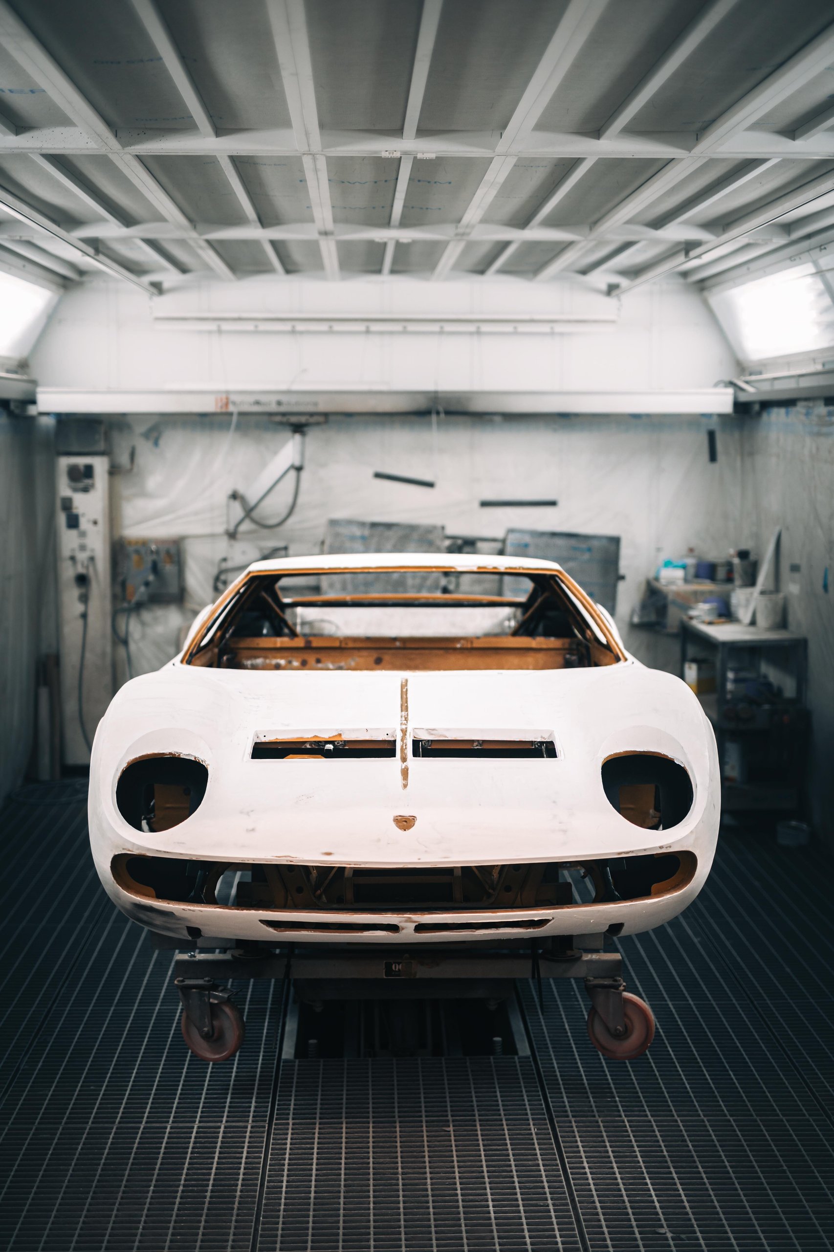 Polo Storico At Ten: Why Lamborghini Let Collectors Get Their Hands Dirty In Sant'Agata 11 Front view of a lamborghini miura body shell in white primer undergoing restoration in the polo storico workshop