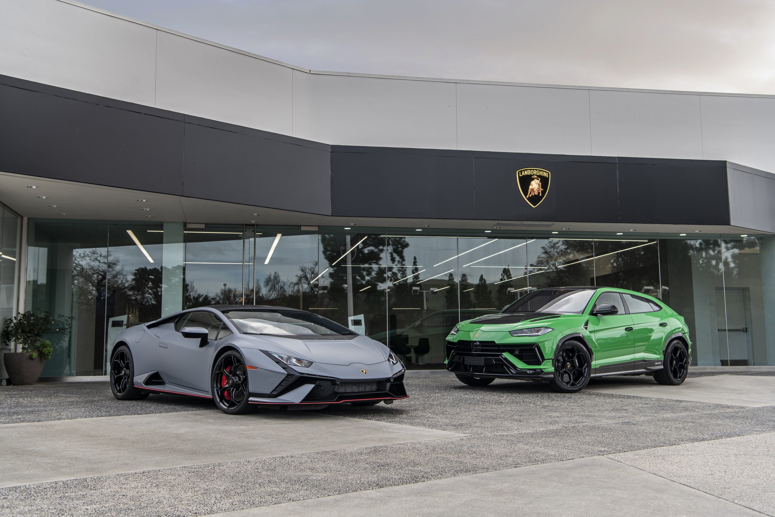 California And Florida Drive Lamborghini'S Record 2022 U.s. Sales As Two Showrooms Debut A New Retail Identity 7 Grey lamborghini huracán tecnica and green urus performante parked side by side in front of a modern lamborghini dealership