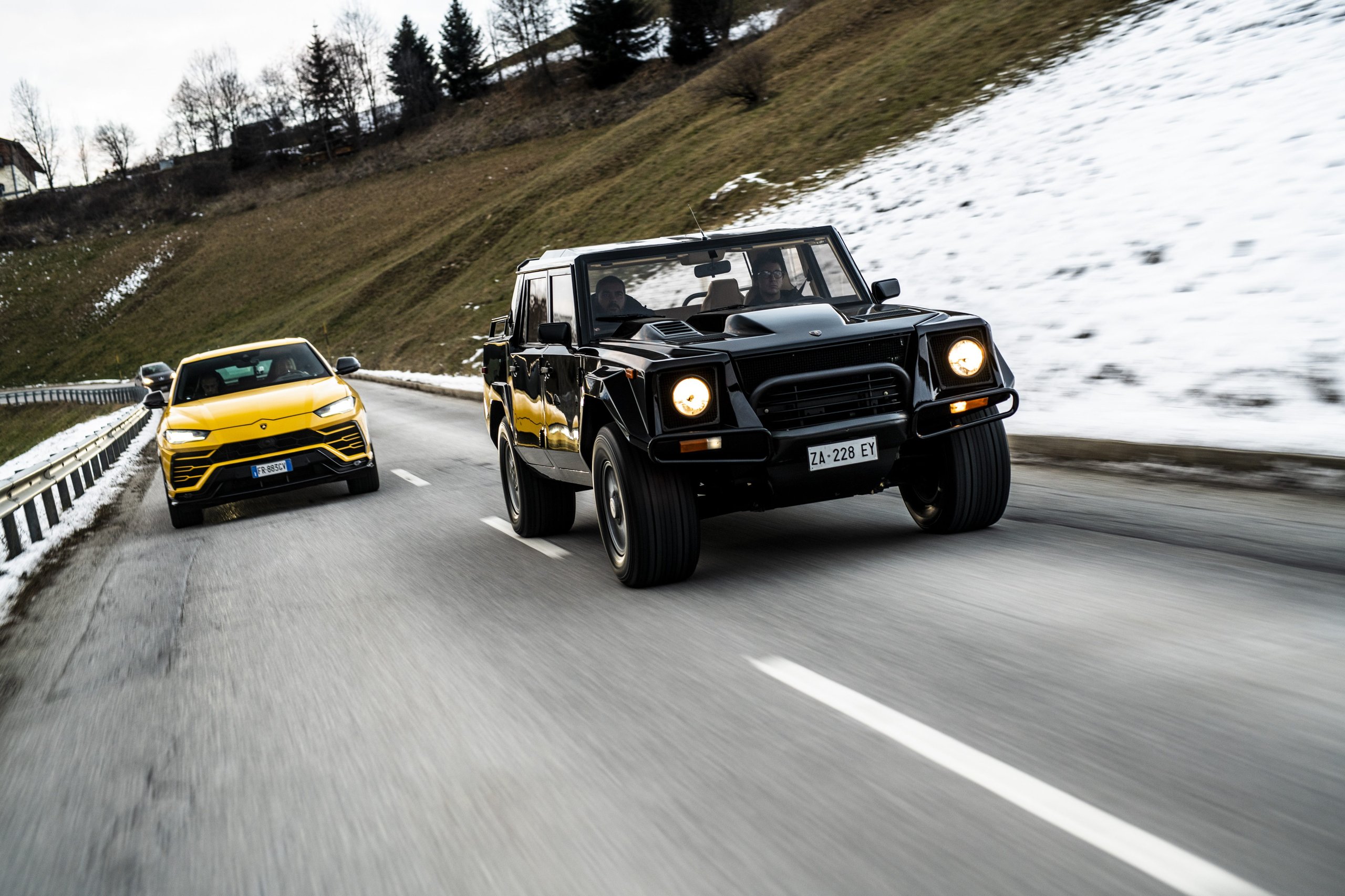 How Five Overlooked Firsts From The Marzal, Miura, Lm002, And Countach Built The Lamborghini You Know Today 9 Black lamborghini lm002 and yellow lamborghini urus driving side by side on a snowy mountain road