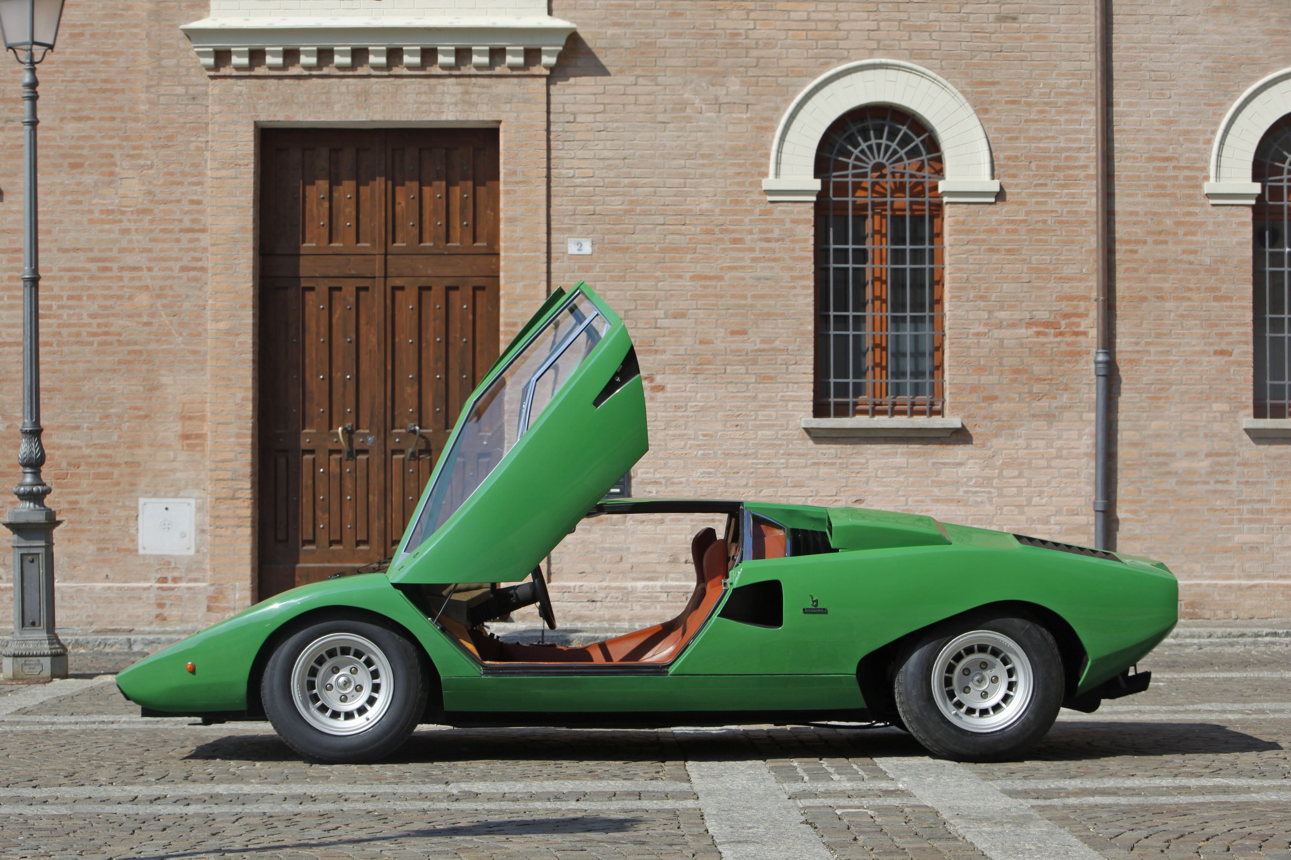 How Five Overlooked Firsts From The Marzal, Miura, Lm002, And Countach Built The Lamborghini You Know Today 11 Green lamborghini countach lp500 prototype with scissor door open on a cobblestone street
