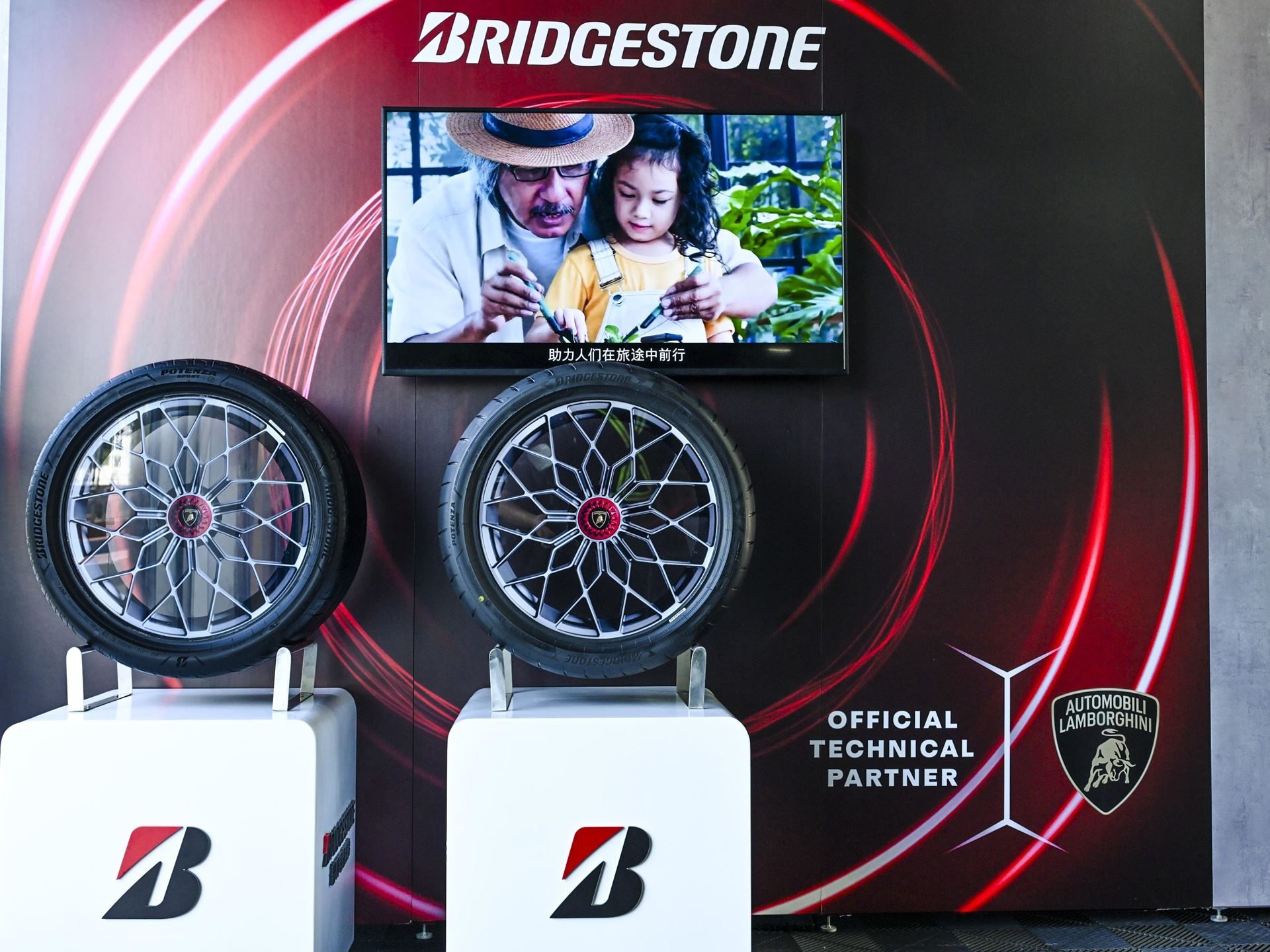 Lamborghini Brought The Revuelto To A Chinese Racetrack To Prove Its V12 Hybrid Belongs There 7 Bridgestone tire and wheel display at esperienza corsa with official technical partner branding and a lifestyle video on screen