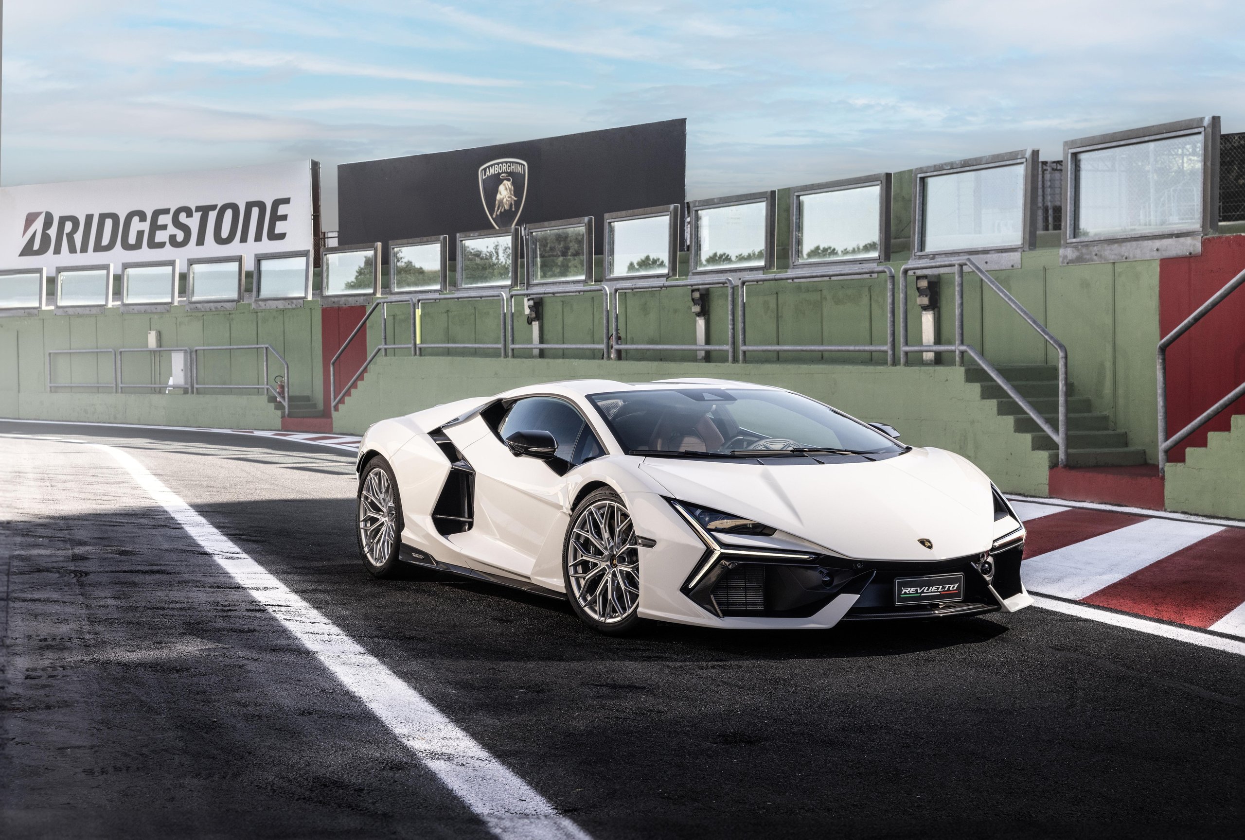 Lamborghini Sent The Revuelto Across Italy To Prove A 1,001 Hp Hybrid Can Still Be A Proper V12 Flagship 9 White lamborghini revuelto parked in a race track pit lane with a bridgestone sign in the background