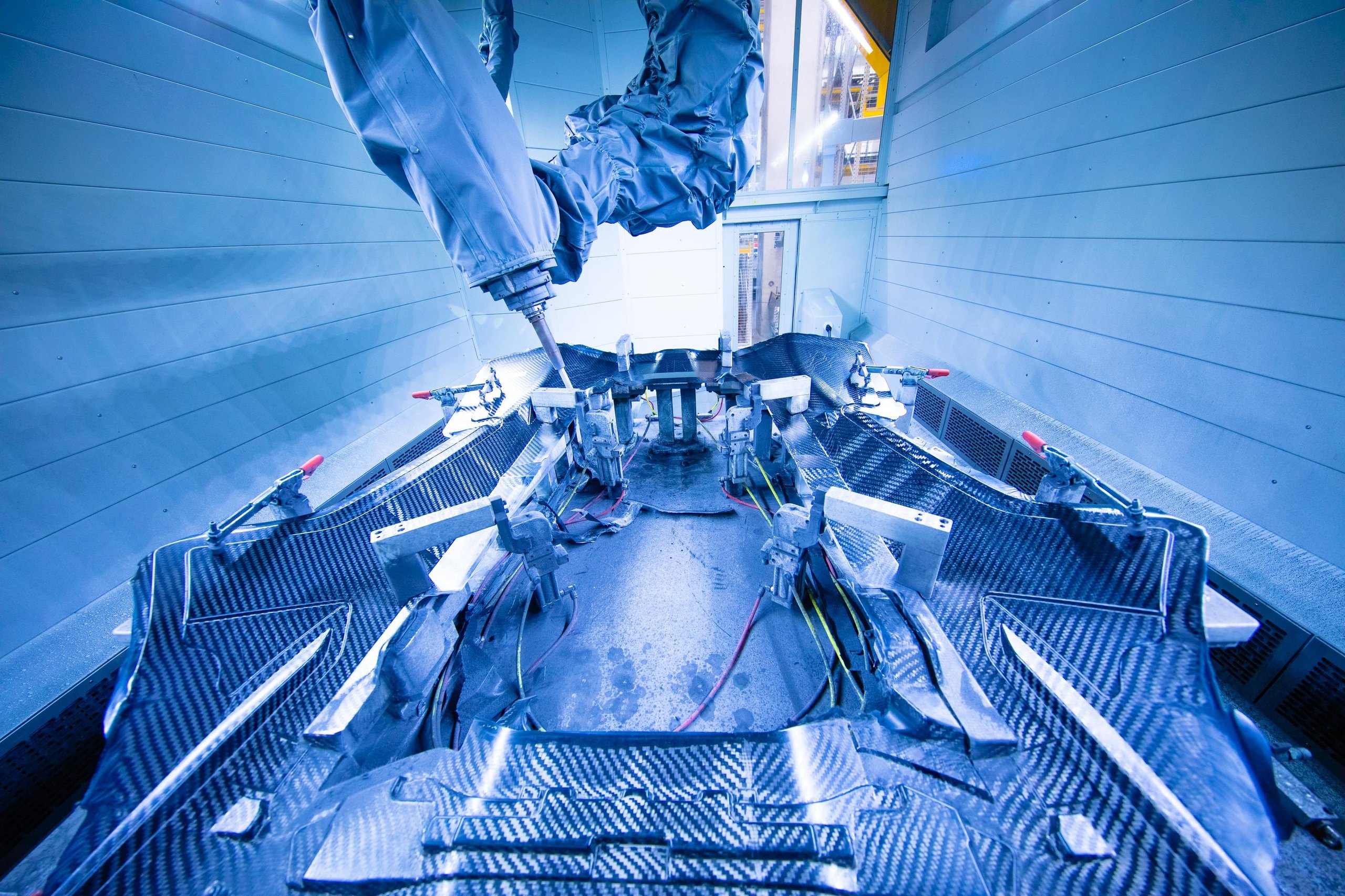 500 Humans, A Fleet Of Cobots, And One Carbon Fiber Tub: How Lamborghini Actually Builds The Revuelto 5 Robotic arm working on the carbon fiber chassis of a lamborghini revuelto
