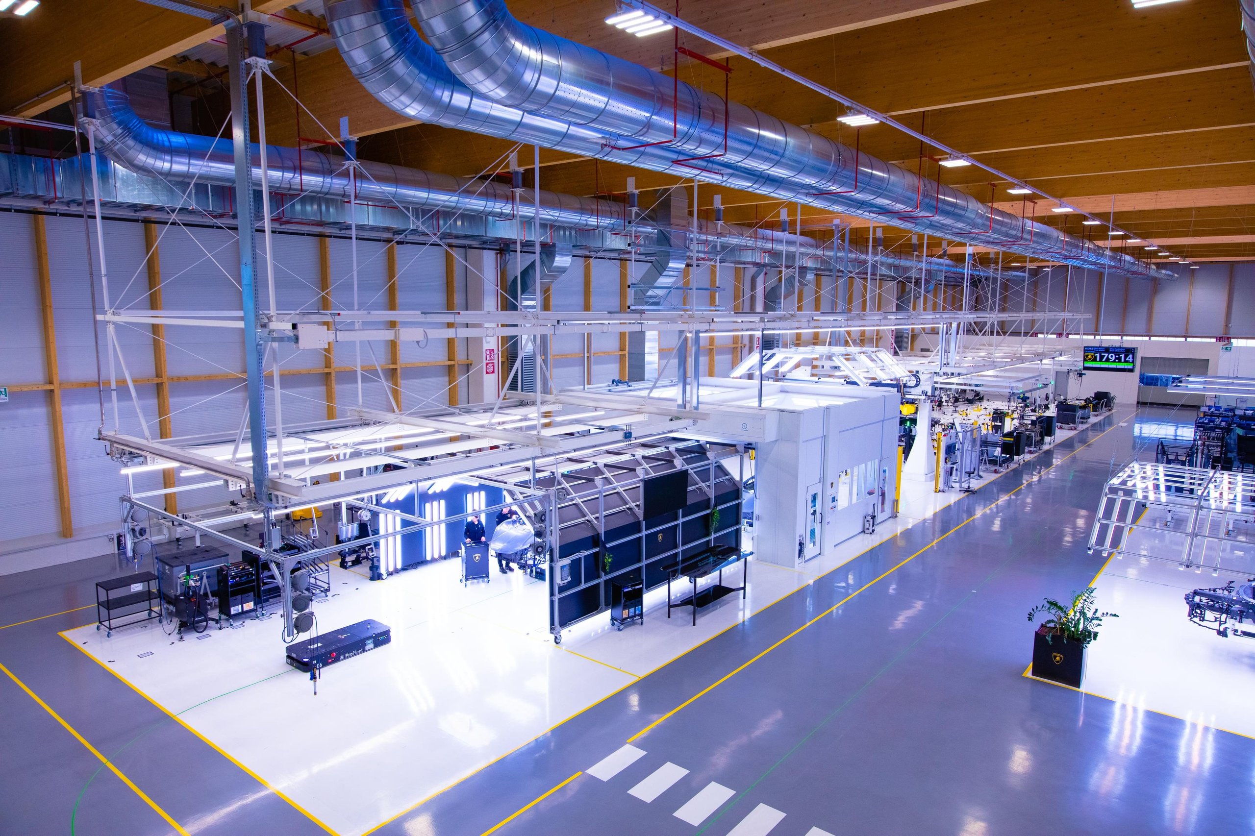 500 Humans, A Fleet Of Cobots, And One Carbon Fiber Tub: How Lamborghini Actually Builds The Revuelto 9 Wide shot of the lamborghini revuelto production line showing multiple assembly stations