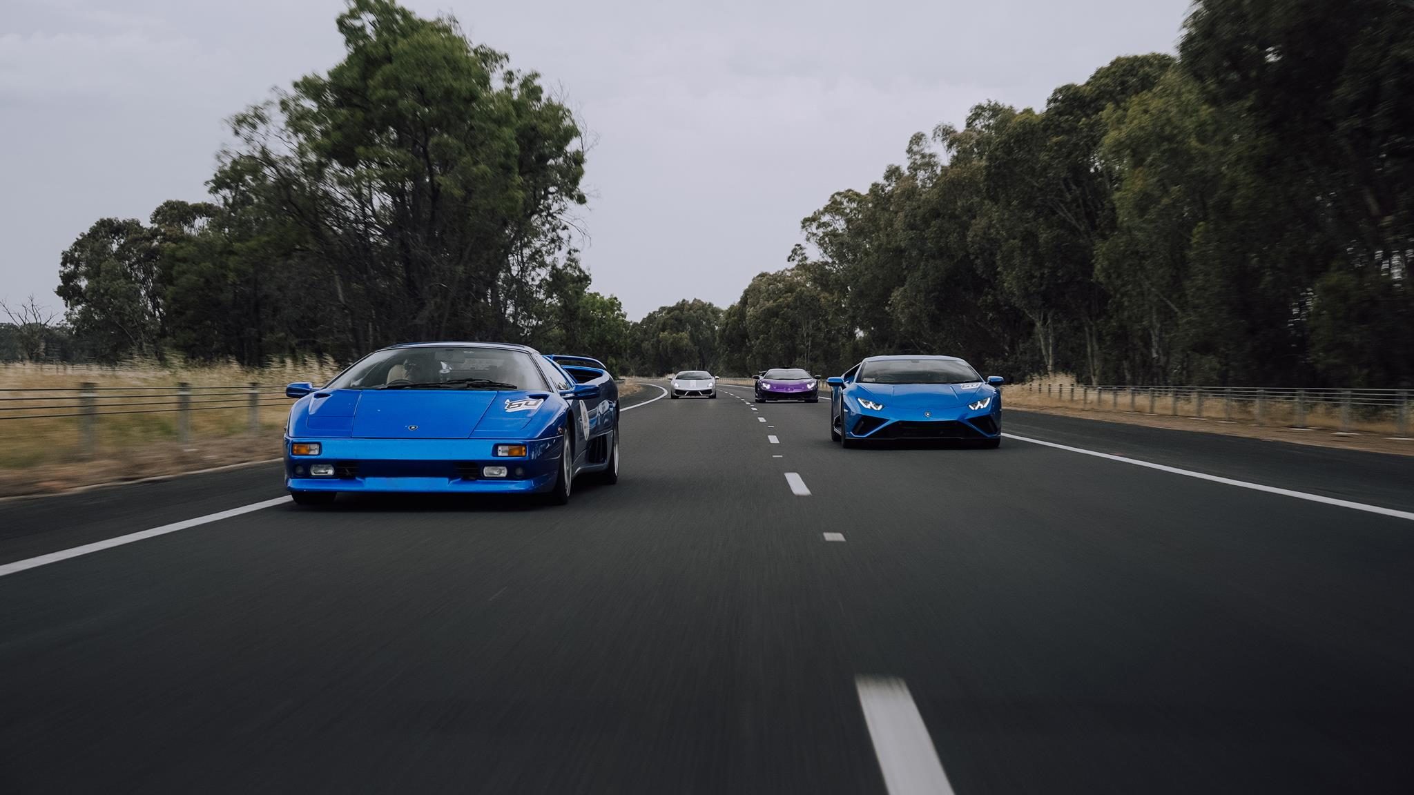 How Lamborghini Turned Melbourne Into A Rolling Museum For The Revuelto'S Oceania Debut 5 Blue lamborghini diablo leading a convoy of modern lamborghinis on a tree-lined highway during the esperienza giro oceania