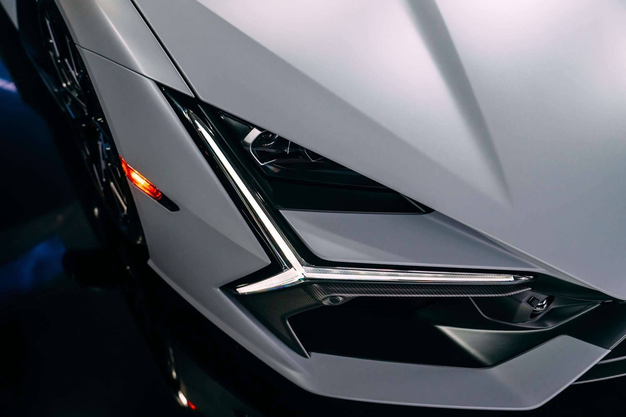 The Lamborghini Revuelto Is The V12 Hybrid That Replaced The Mighty Aventador 3 Close-up of the lamborghini revuelto's y-shaped drl headlight and sharp front fender creases