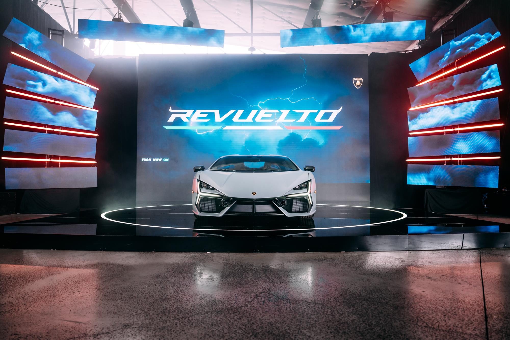 How Lamborghini Turned Melbourne Into A Rolling Museum For The Revuelto'S Oceania Debut 3 White lamborghini revuelto on stage at melbourne debut with revuelto logo and lightning graphics on screen