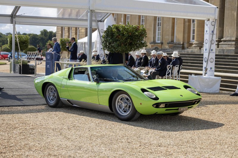 A lime green Lamborghini Miura displayed on a gravel path at Blenheim Palace during Salon Privé, with elegantly dressed attendees in the background
