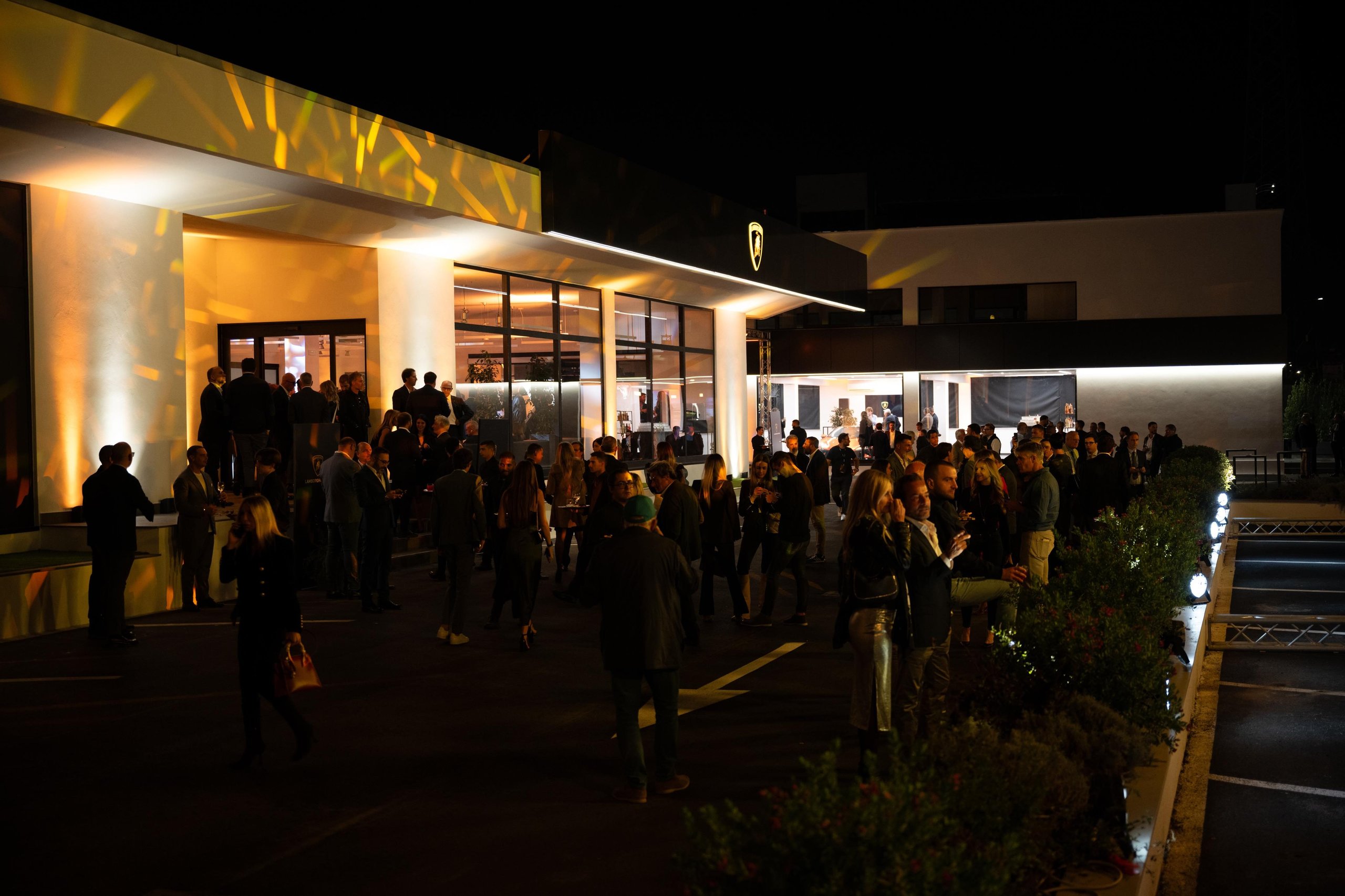 Lamborghini'S New Rome Flagship Pairs A Miura With The Revuelto To Sell Its Electrified Future 3 Large crowd gathered outside the illuminated new lamborghini rome dealership at night during the inauguration event