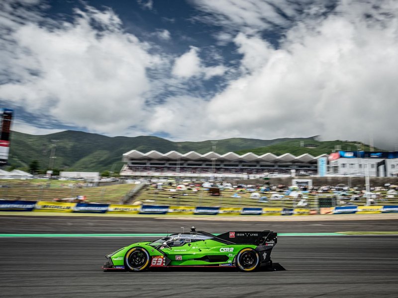 Lamborghini SC63 racing at speed on the Fuji Speedway circuit with mountains and grandstands blurred in the background
