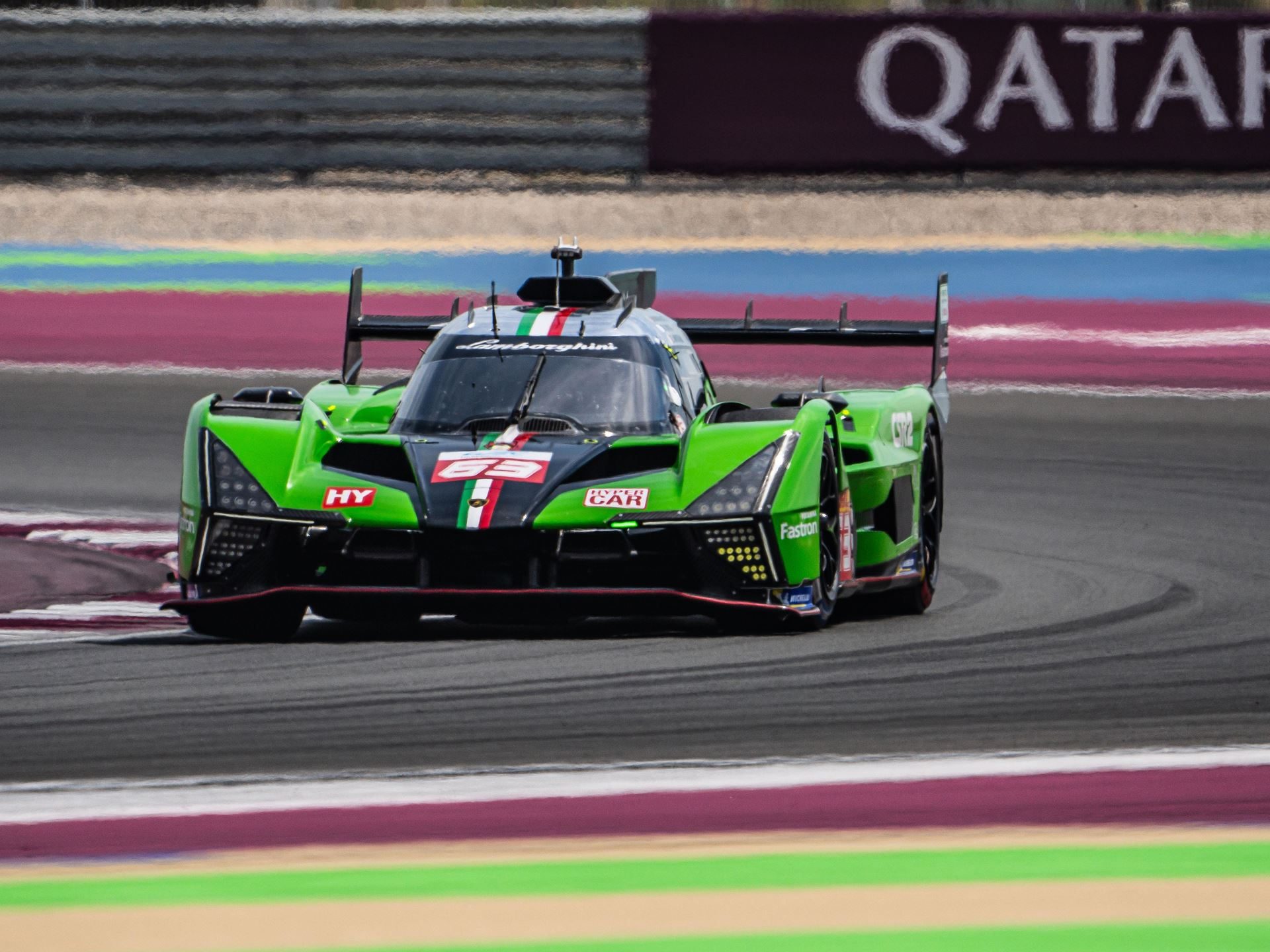 Lamborghini Sc63 Heads To Le Mans Carrying Points, Progress, And One Cracked Axle 3 Lamborghini sc63 cornering on track with qatar signage visible in the background