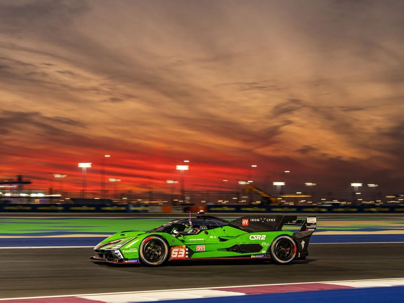 Lamborghini SC63 race car speeding on track at dusk with orange and purple sky