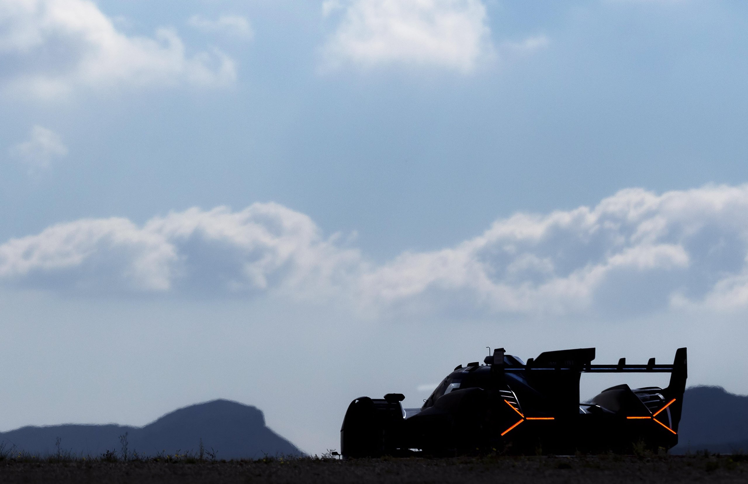 The Sc63 Lmdh Looked Like Lamborghini'S Future. Then The Future Changed. 7 Silhouette of the lamborghini sc63 against a bright sky showing its rear diffuser, rear wing, and signature y-shaped orange taillights