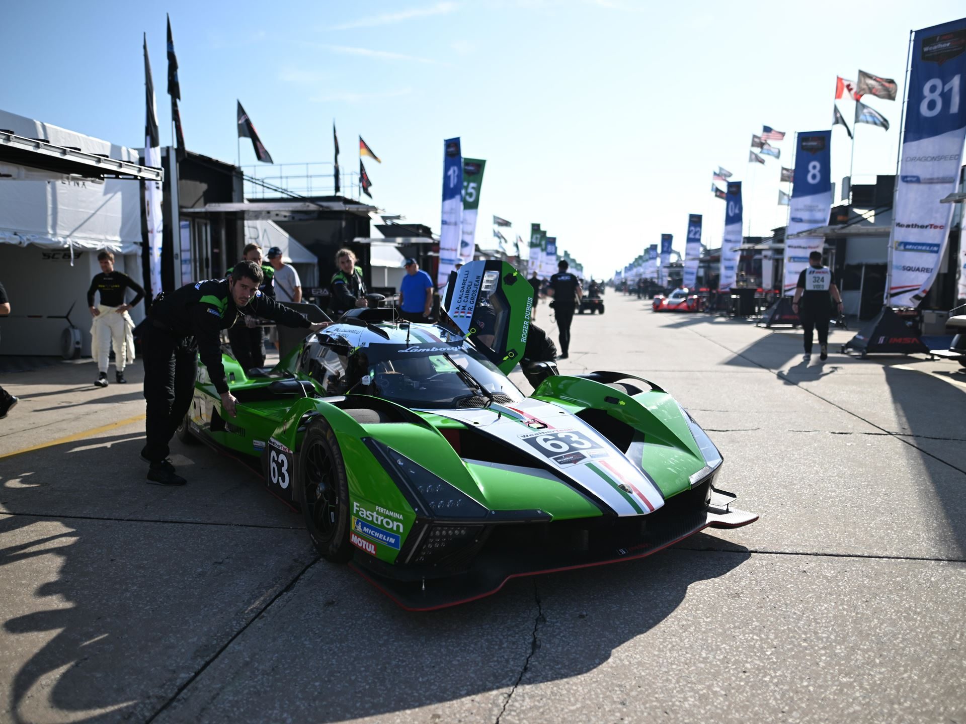 Lamborghini'S Sc63 Lmdh Arrives At Sebring To Learn, Not To Win 7 Lamborghini sc63 parked in the paddock area with team members and pit garages in the background