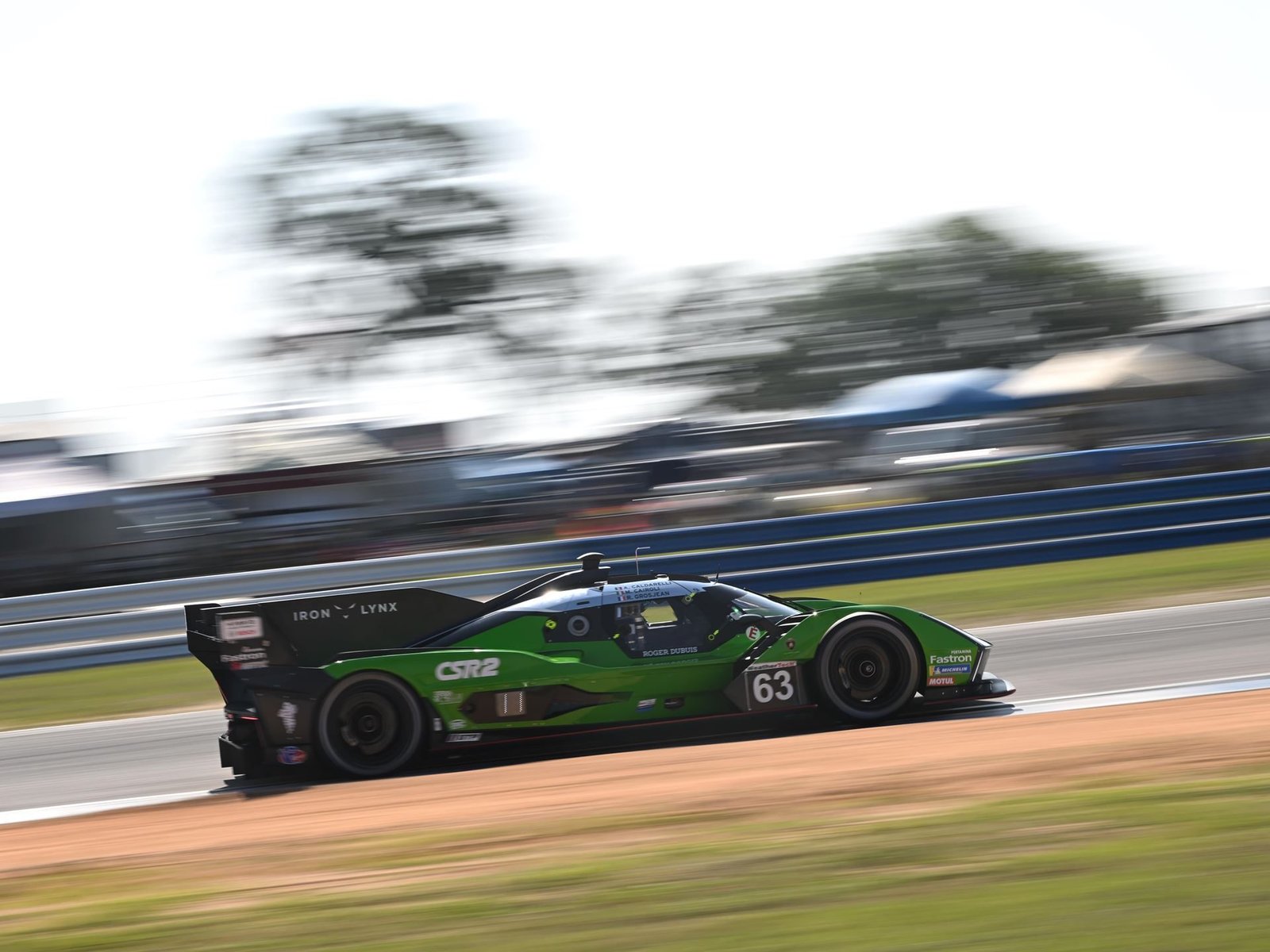 Lamborghini SC63 LMDh race car at speed on track with motion blur emphasizing velocity