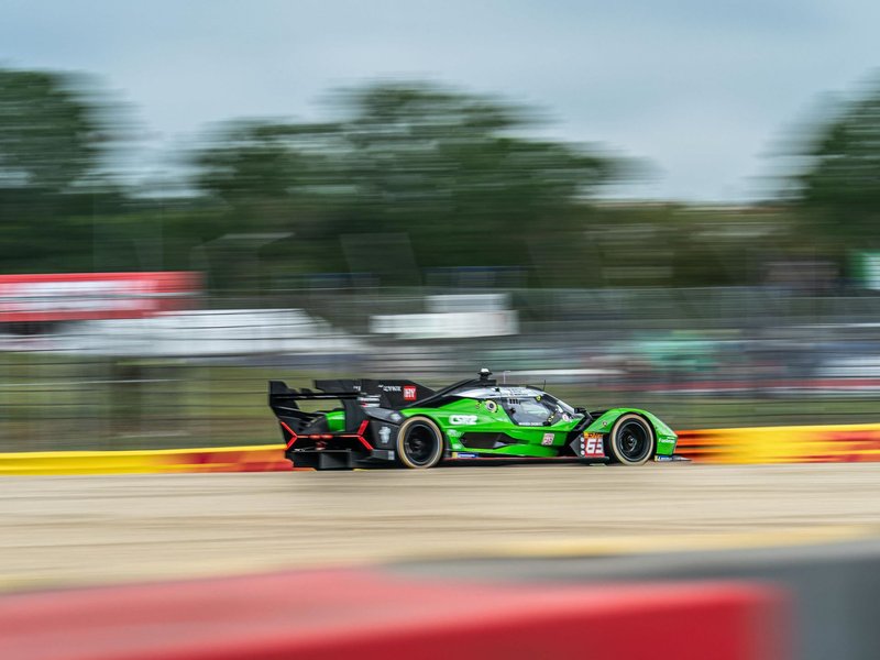 Lamborghini SC63 LMDh prototype at speed on track in green and black racing livery
