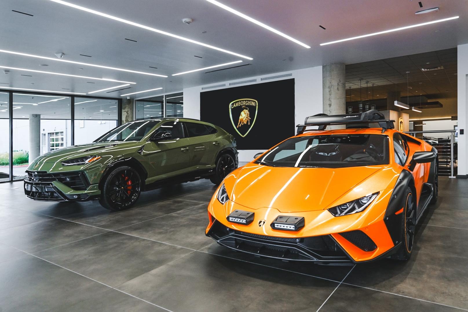 Lamborghini Seattle Opens In Bellevue With The Revuelto As Its Centerpiece, And That Pairing Tells You Everything About The Brand'S Strategy 3 Olive green lamborghini urus performante and orange huracán sterrato displayed inside the new lamborghini seattle showroom
