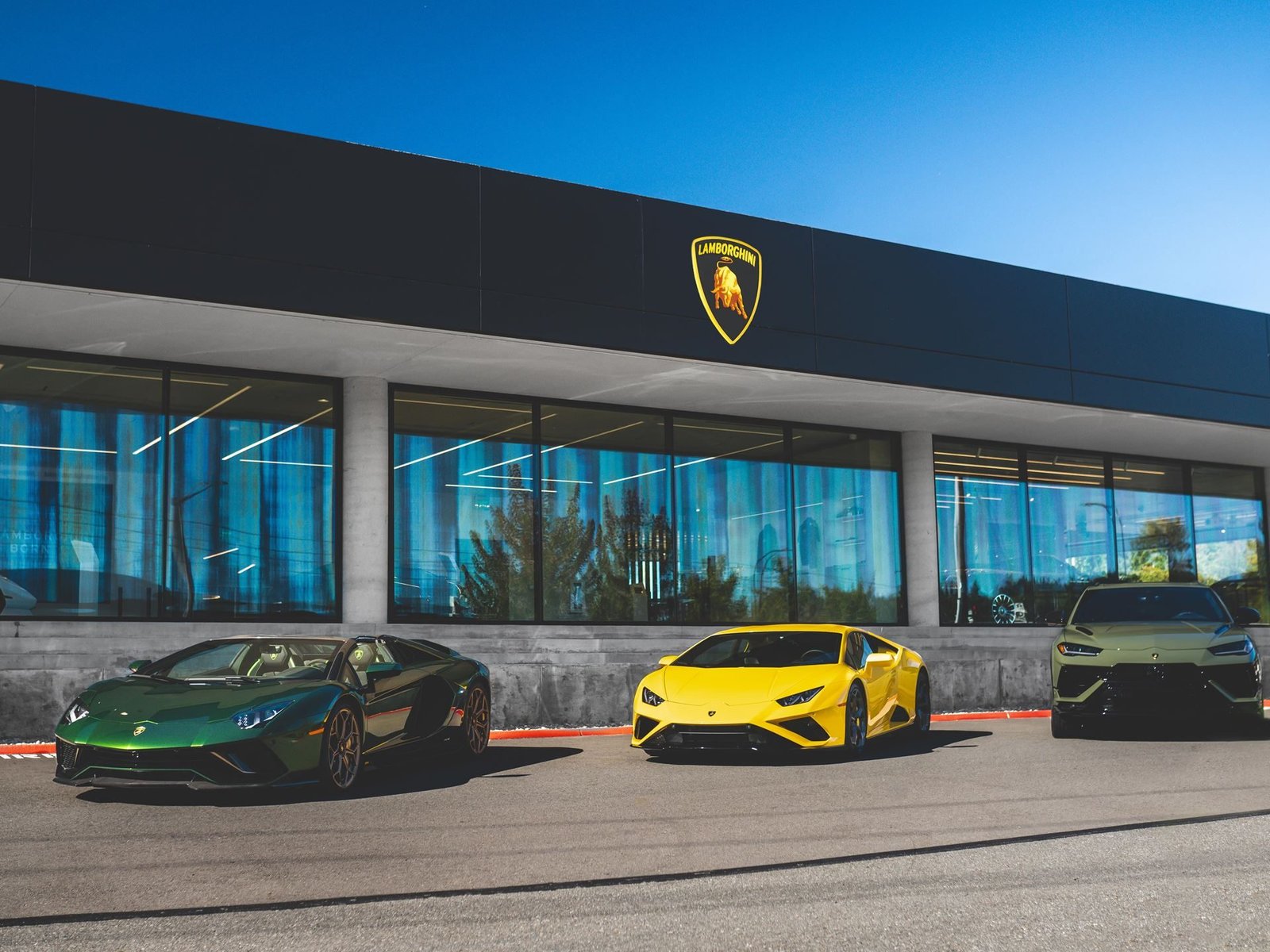 Three Lamborghini models parked outside the new Lamborghini Seattle showroom in Bellevue, Washington