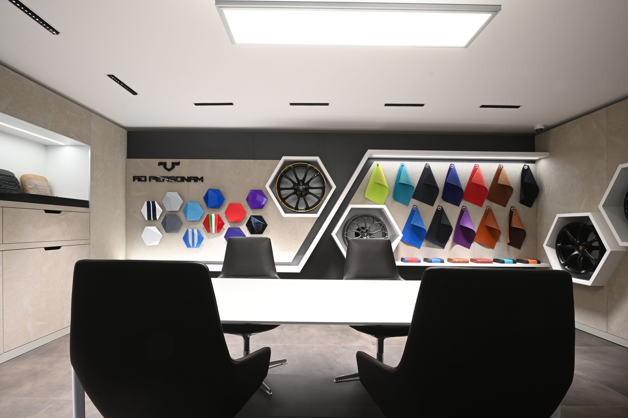 Lamborghini Prague Reopens With Urus Performante Premiere And A Glimpse Of What Comes Next 5 Interior of the ad personam studio at lamborghini prague, showing a consultation table with paint samples, wheel options, and material swatches