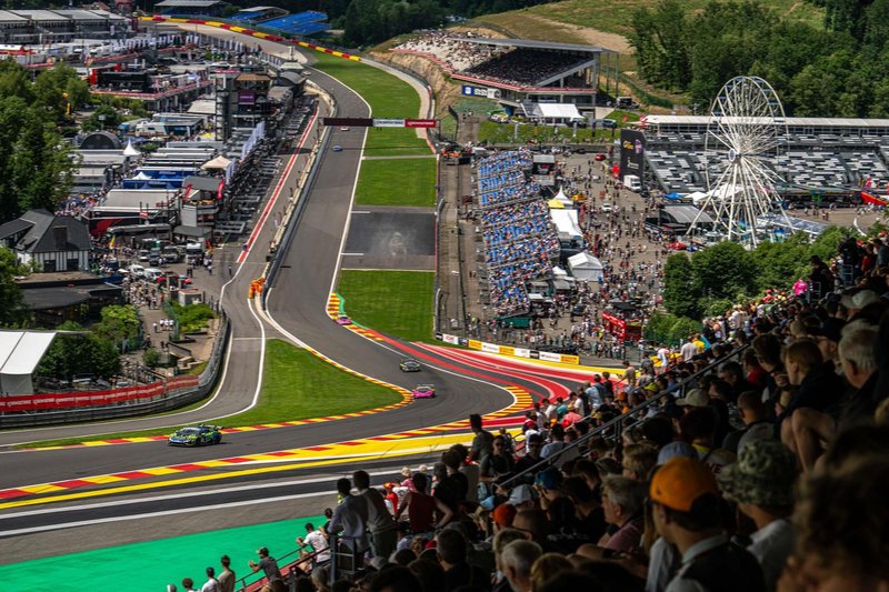 Aerial view of Lamborghini Super Trofeo Europe race cars on the Spa-Francorchamps circuit with packed grandstands and green Belgian landscape