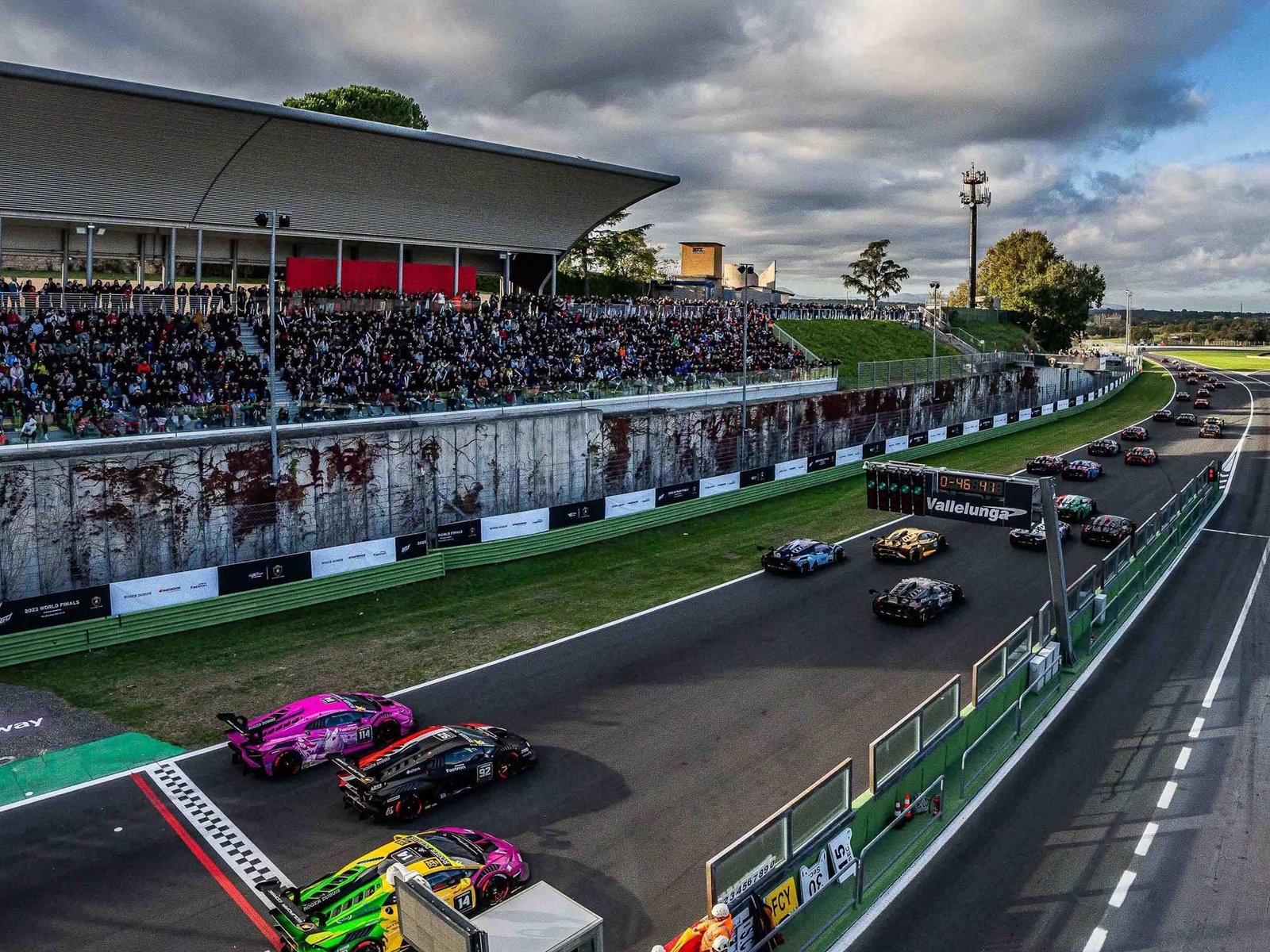 Multiple Lamborghini Huracán Super Trofeo race cars on track at Vallelunga with spectators in the grandstands