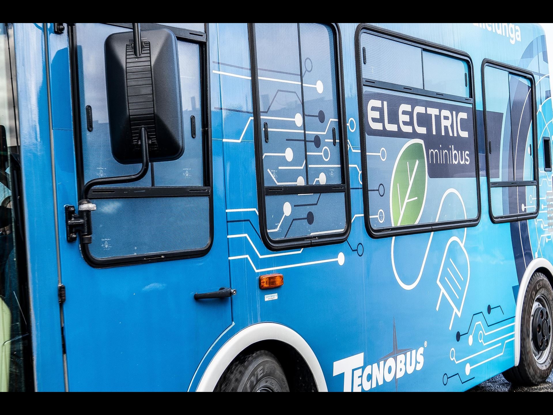 Lamborghini'S 2023 Super Trofeo World Finals Earned Iso 20121 Certification For Sustainable Event Management 5 Blue electric minibus with 'electric minibus' branding and circuit board graphics used at the super trofeo world finals