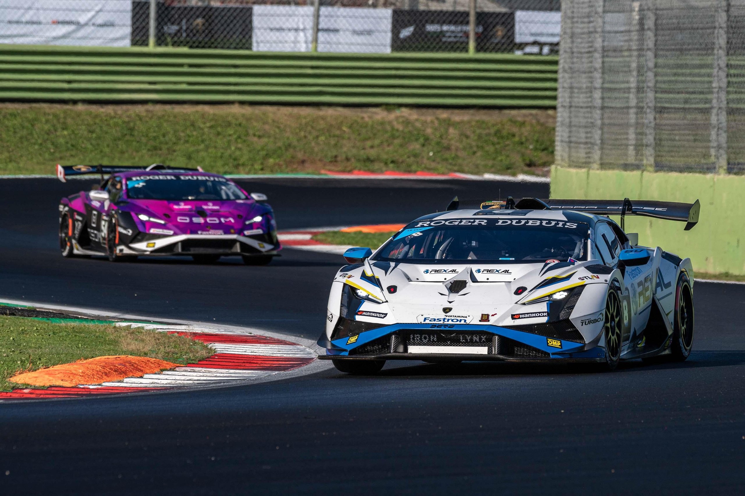 Leitch Claims European Pro Title In Thrilling Lamborghini Super Trofeo Finale That Crowned Champions Across Three Continents 9 Two lamborghini huracán super trofeo evo2 race cars navigating a turn in close competition under bright sunlight