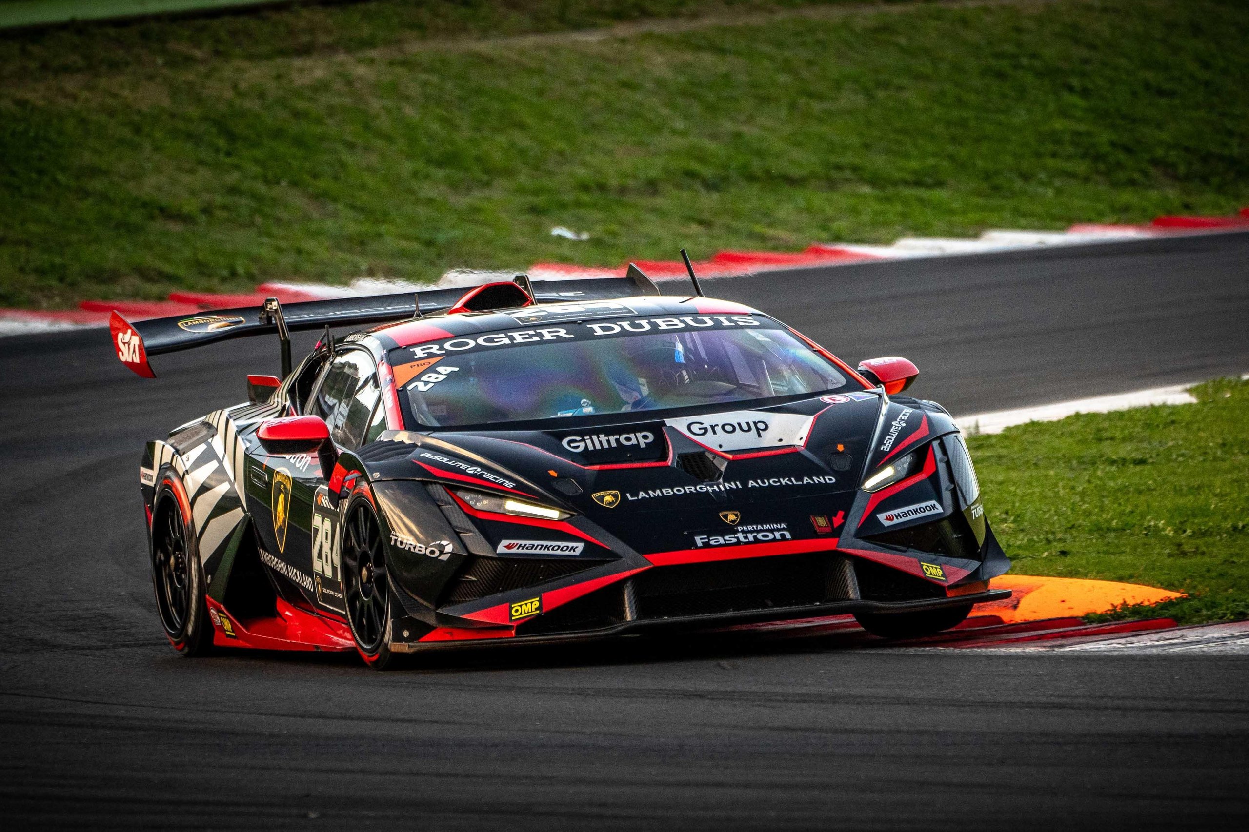Leitch Claims European Pro Title In Thrilling Lamborghini Super Trofeo Finale That Crowned Champions Across Three Continents 11 Black lamborghini huracán super trofeo evo2 with red accents at speed through a racetrack corner
