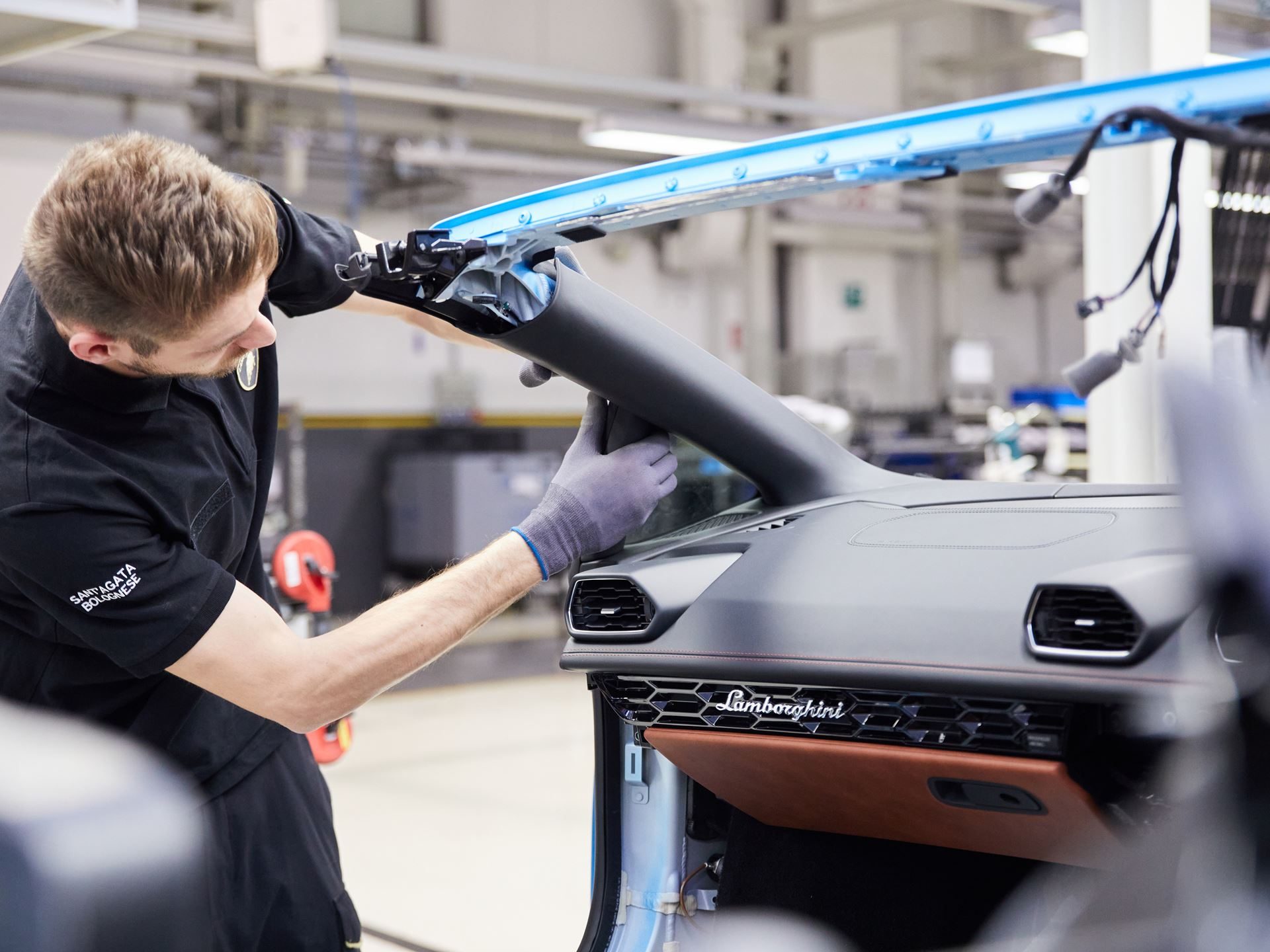 How Lamborghini'S Chief Procurement Officer Kept The Factory Running Through Pandemic, Chip Shortage, And War 5 A lamborghini technician in black uniform meticulously installs a component onto a huracán dashboard