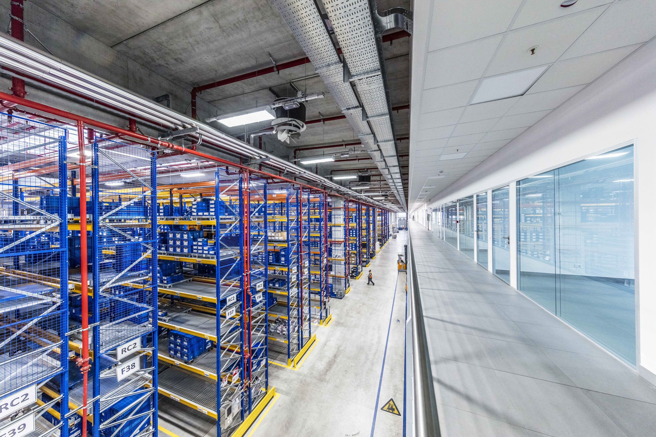 How Lamborghini'S Chief Procurement Officer Kept The Factory Running Through Pandemic, Chip Shortage, And War 9 A vast modern lamborghini warehouse with towering shelving units filled with organized parts and components